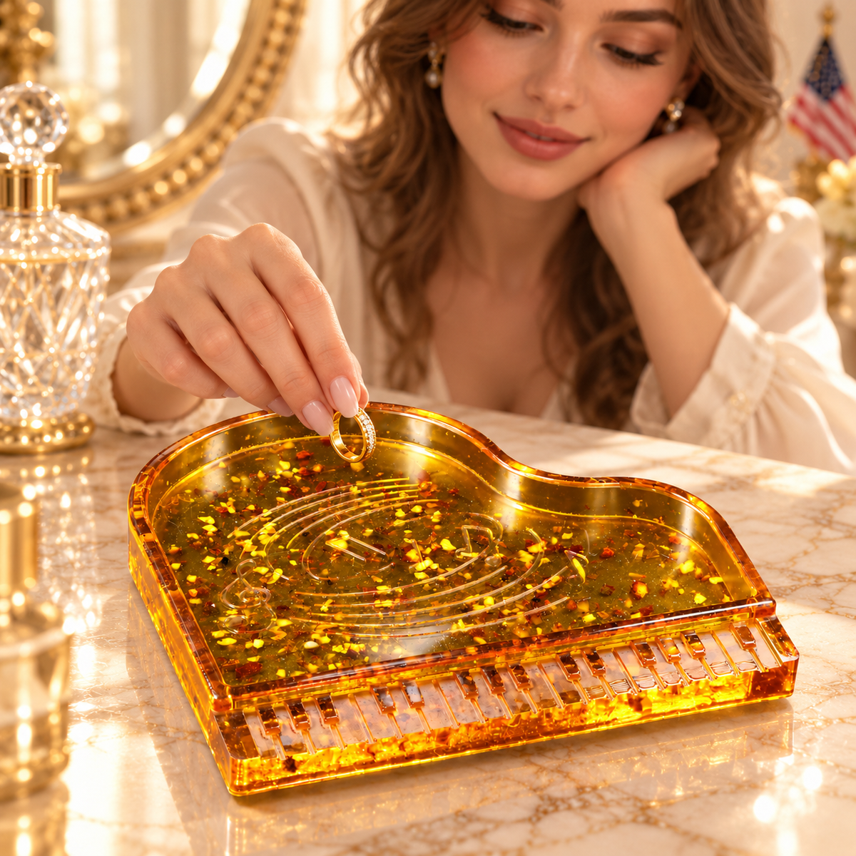 Young adult woman placing a gold ring into the shallow KIZIMA Baltic amber grand piano jewelry dish at a marble vanity