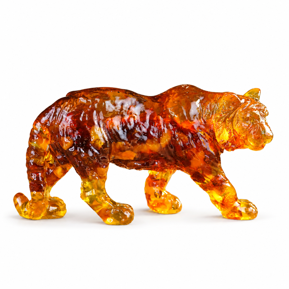 KIZIMA Baltic amber tiger sculpture isolated on white, full right-facing profile with a soft shadow.