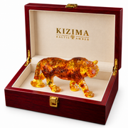 KIZIMA Baltic amber tiger sculpture in an open red wooden gift box with cream lining, on a white background.