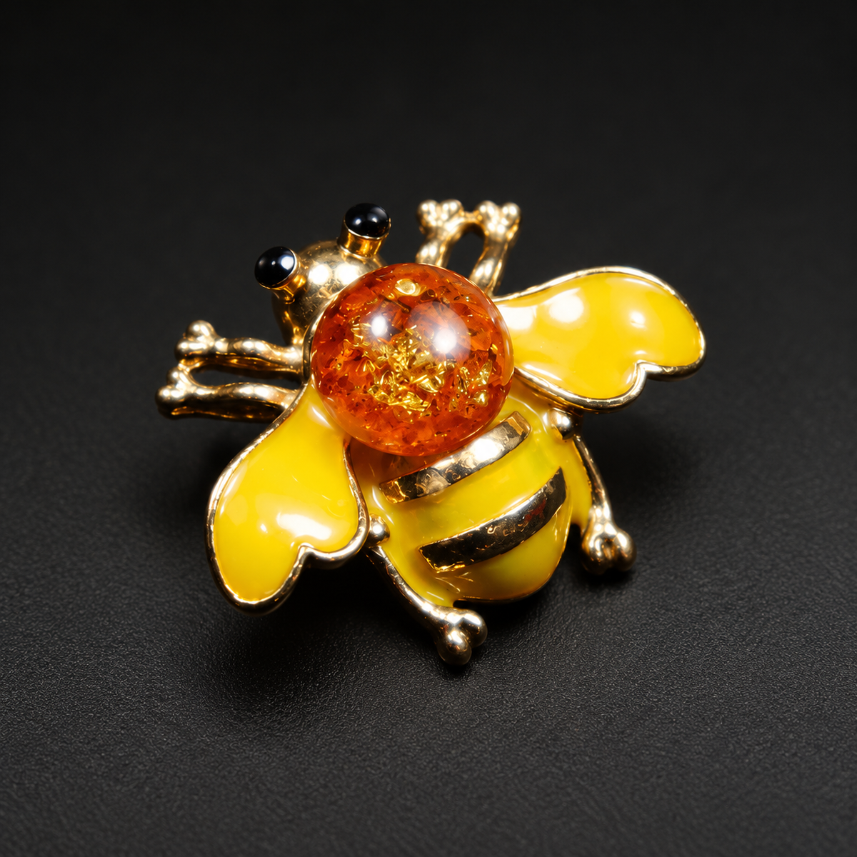 KIZIMA yellow enamel and cognac Baltic amber bee brooch 20-306Q5-3-3-2 on a black studio background.