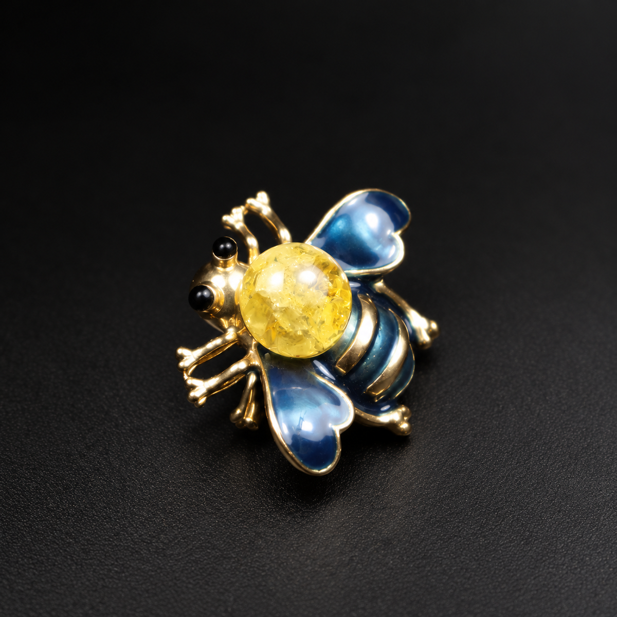 KIZIMA blue enamel and lemon Baltic amber bee brooch 20-308Q5-3-3-2 on a black studio background.