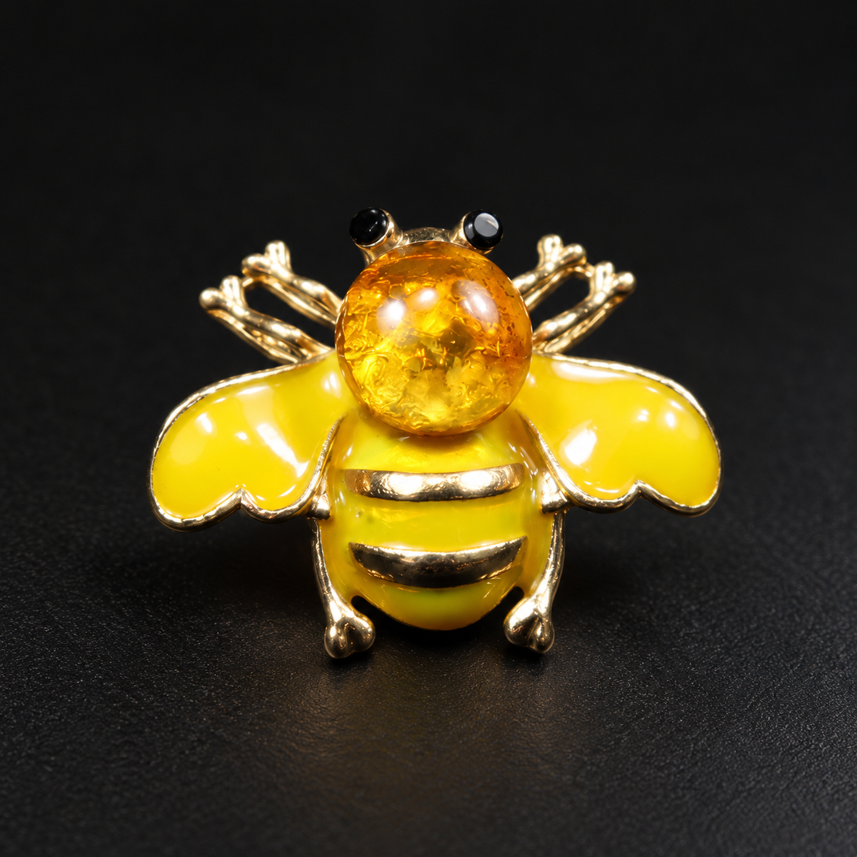 KIZIMA yellow enamel bee brooch 20N0120-35 with round Baltic amber on a black studio background.