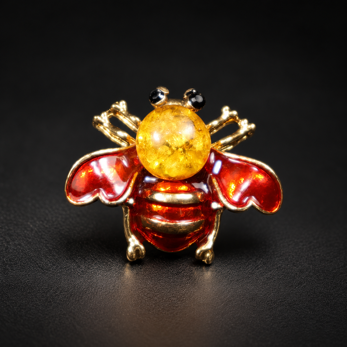 KIZIMA red enamel bee brooch 20N0120-36 with round Baltic amber on a black studio background.
