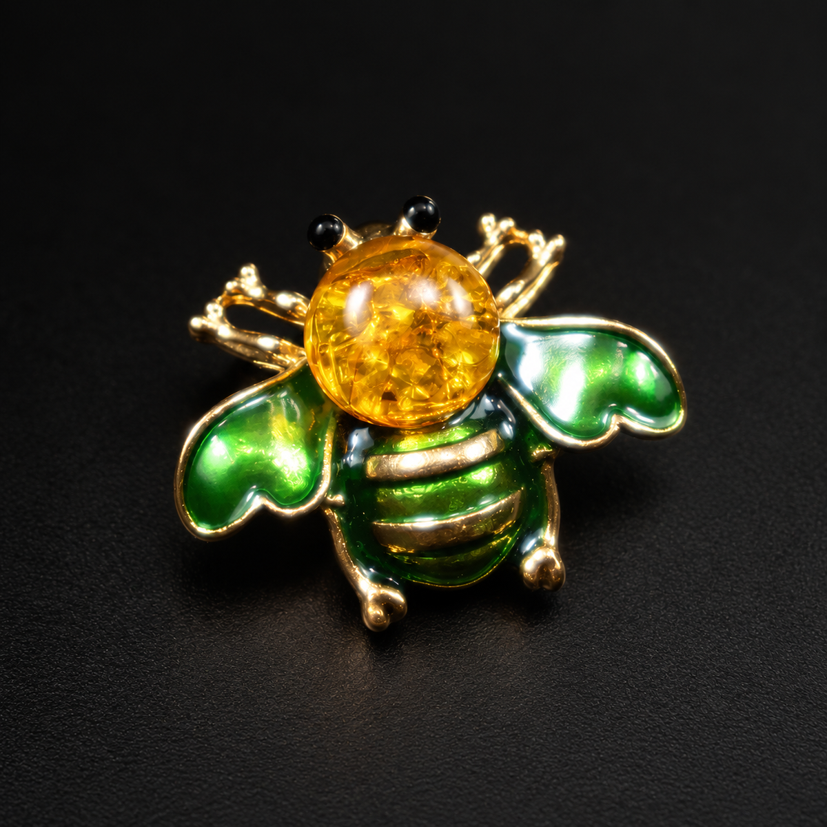 KIZIMA green enamel bee brooch 20N0120-40 with round Baltic amber on a black studio background.