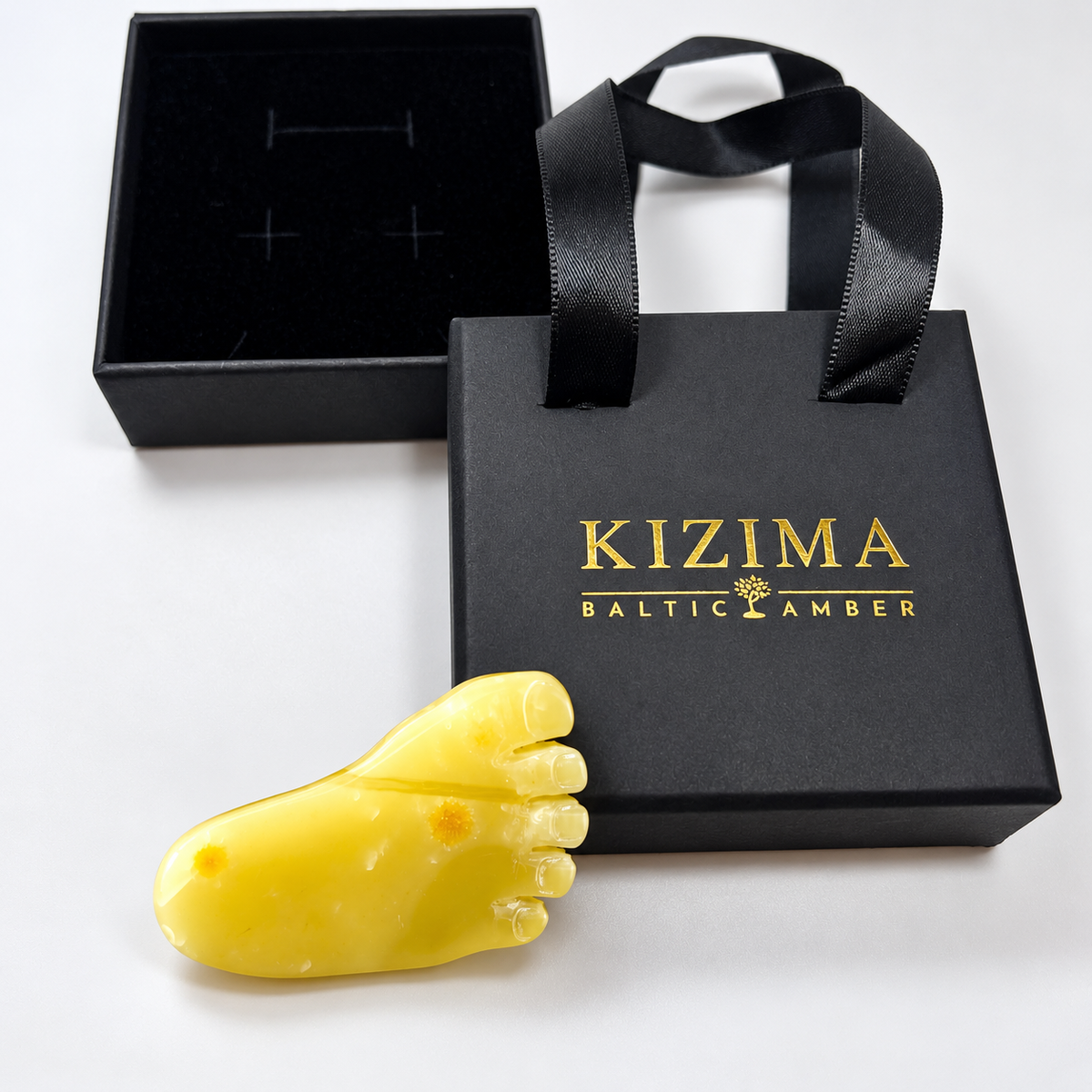 KIZIMA Baltic amber brooch 20S0885q2.95 beside authentic black KIZIMA gift packaging.