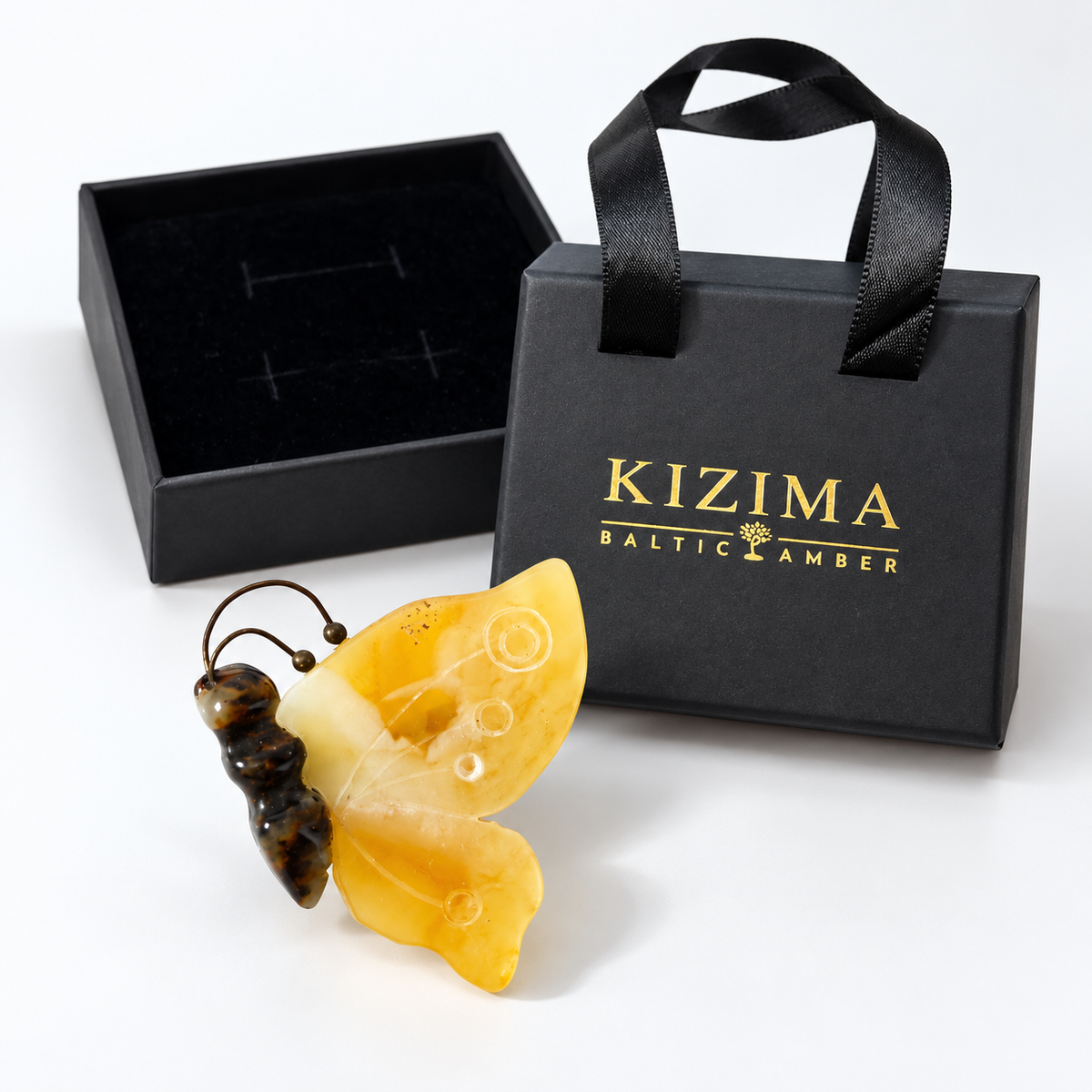 KIZIMA yellow amber butterfly brooch beside authentic black gift box and KIZIMA Baltic Amber bag.