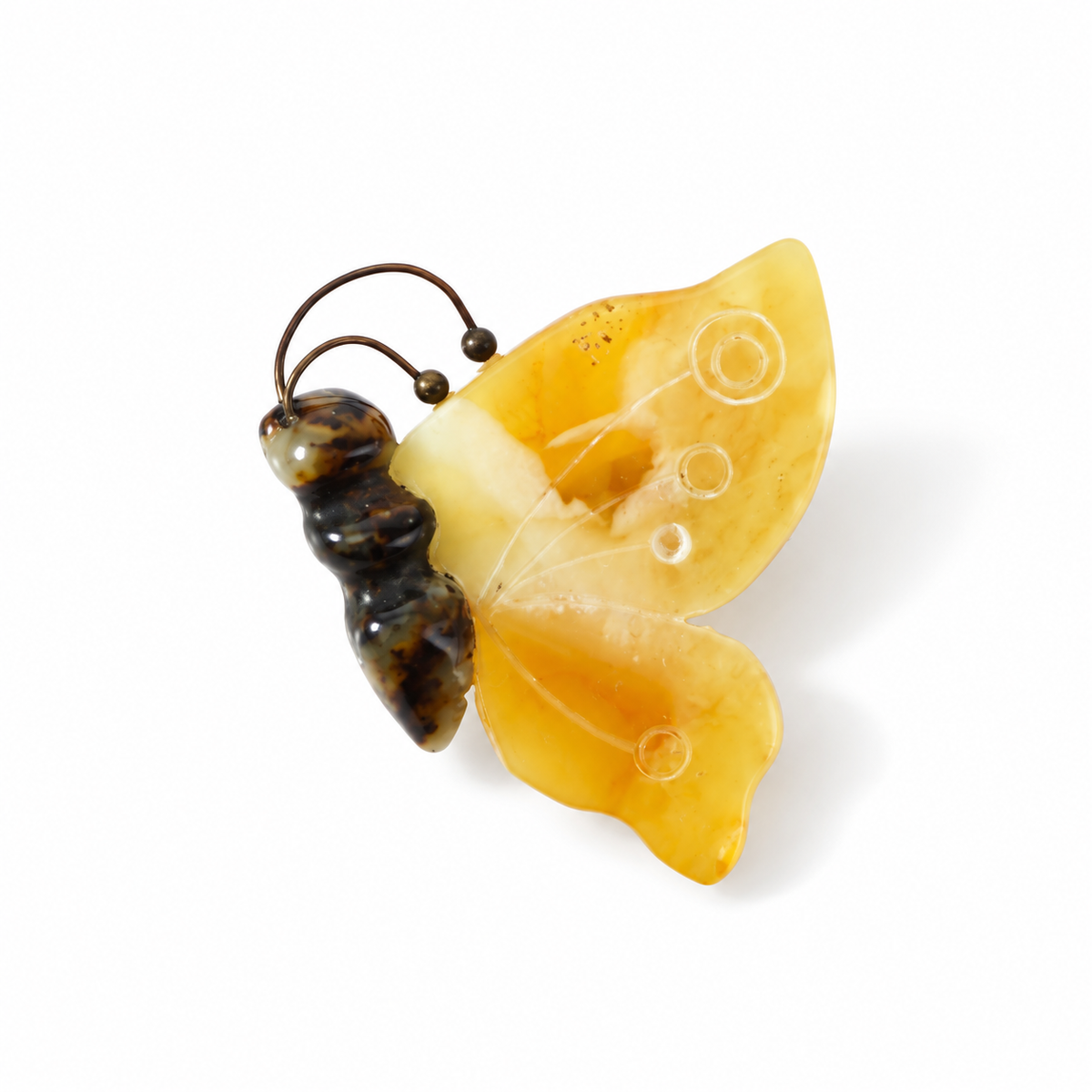 KIZIMA yellow amber butterfly brooch with carved circles and dark body on white background.