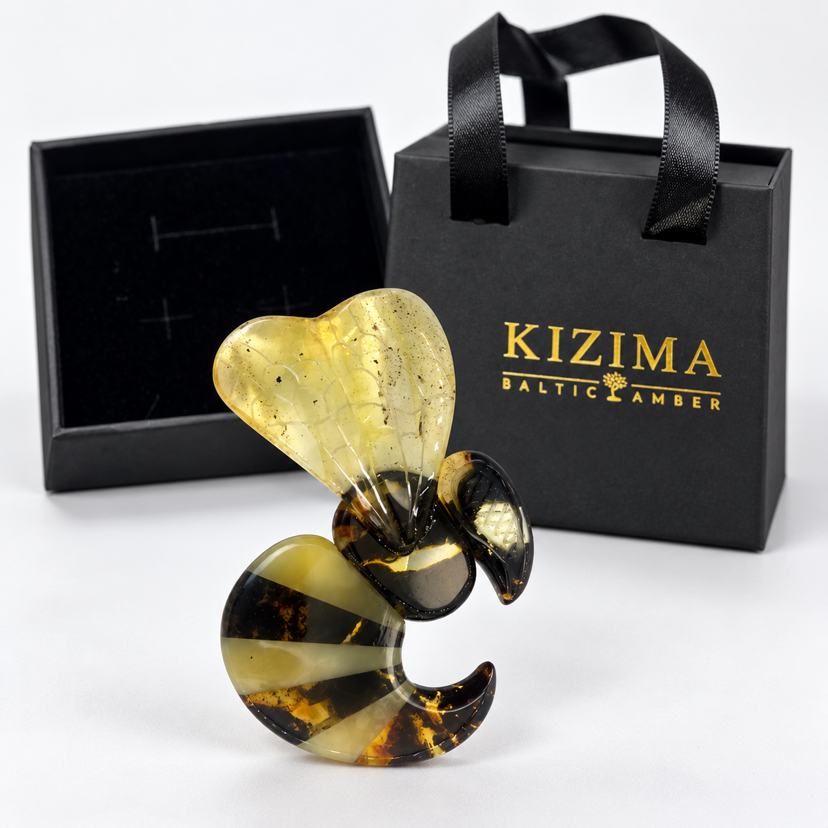 KIZIMA Baltic amber brooch 20S2049q6.83 beside authentic black KIZIMA gift packaging.