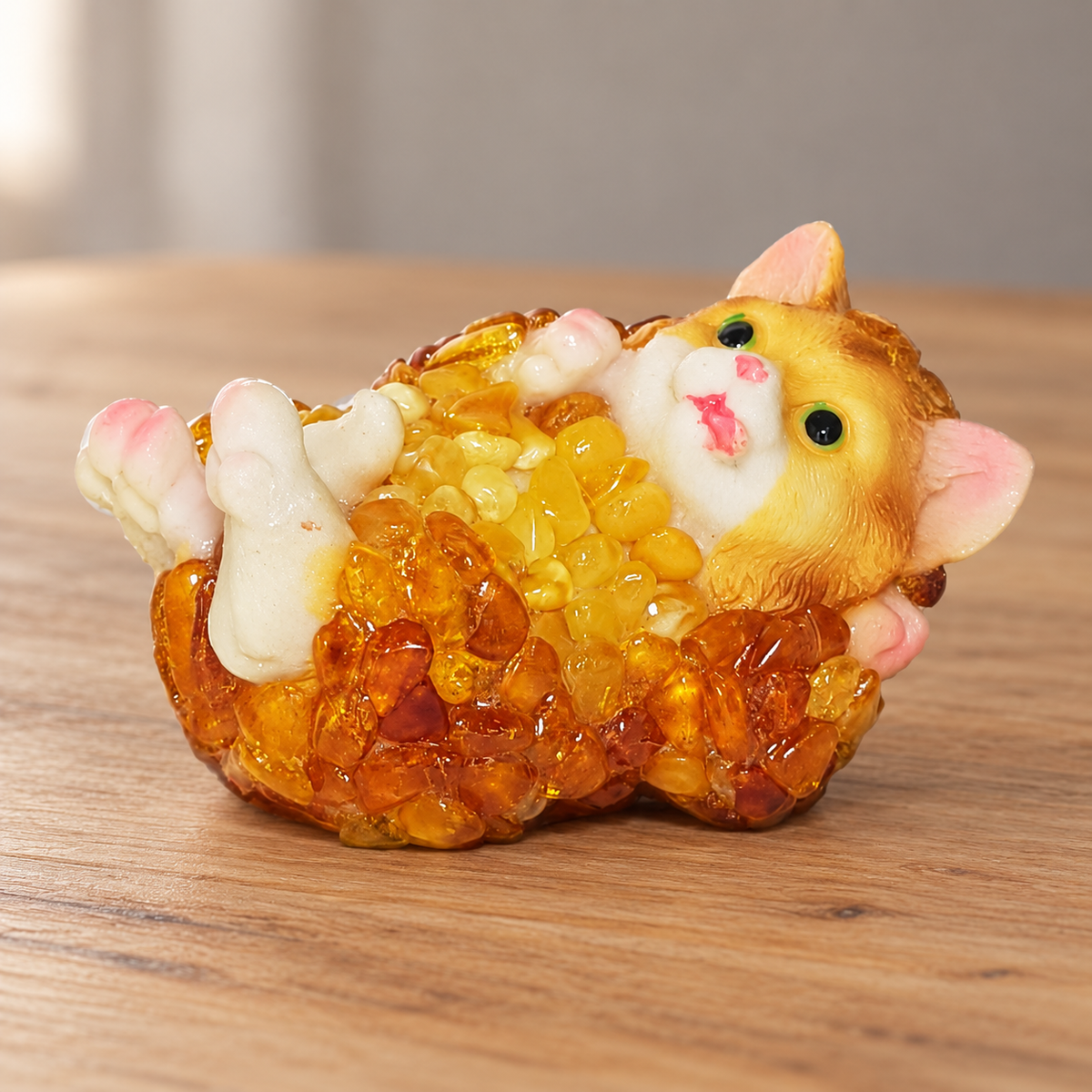 Baltic amber cat figurine on its back on a shelf in a softly lit home interior — handmade in Brooklyn by KIZIMA®
