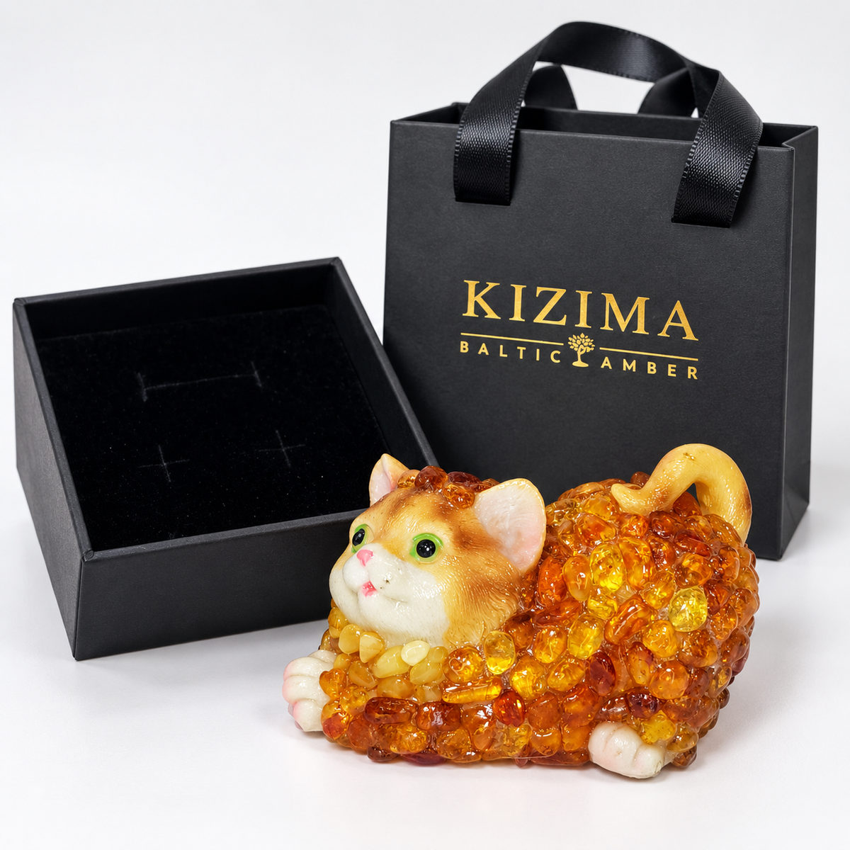 Baltic amber lying cat figurine with black velvet-lined KIZIMA® gift box and gift bag — ready-to-give cat lover gift
