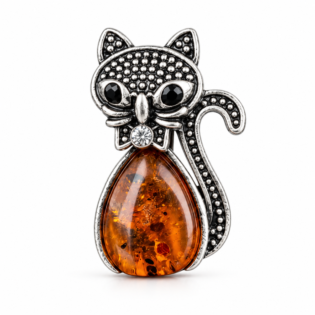 KIZIMA silver-tone cat brooch 20-205Q4-3-1-1 with cognac Baltic amber belly, black eyes and a crystal bow on a white studio background.
