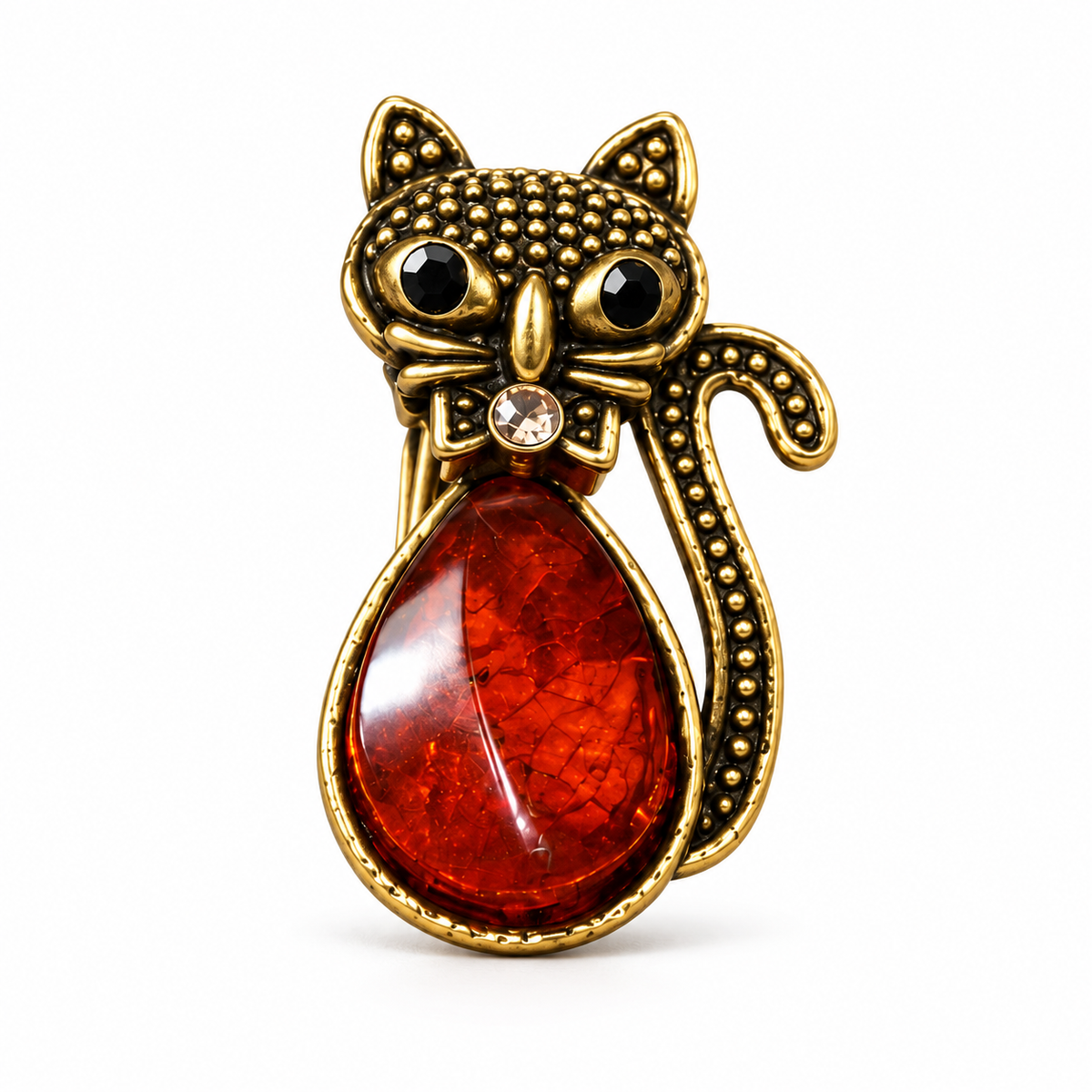 KIZIMA gold-tone cat brooch 20-206Q4-3-1-1 with reddish cognac Baltic amber belly, black eyes and a crystal bow on a white studio background.