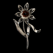 KIZIMA silver-tone seven-petal daisy with dark cognac amber center brooch on black studio background.