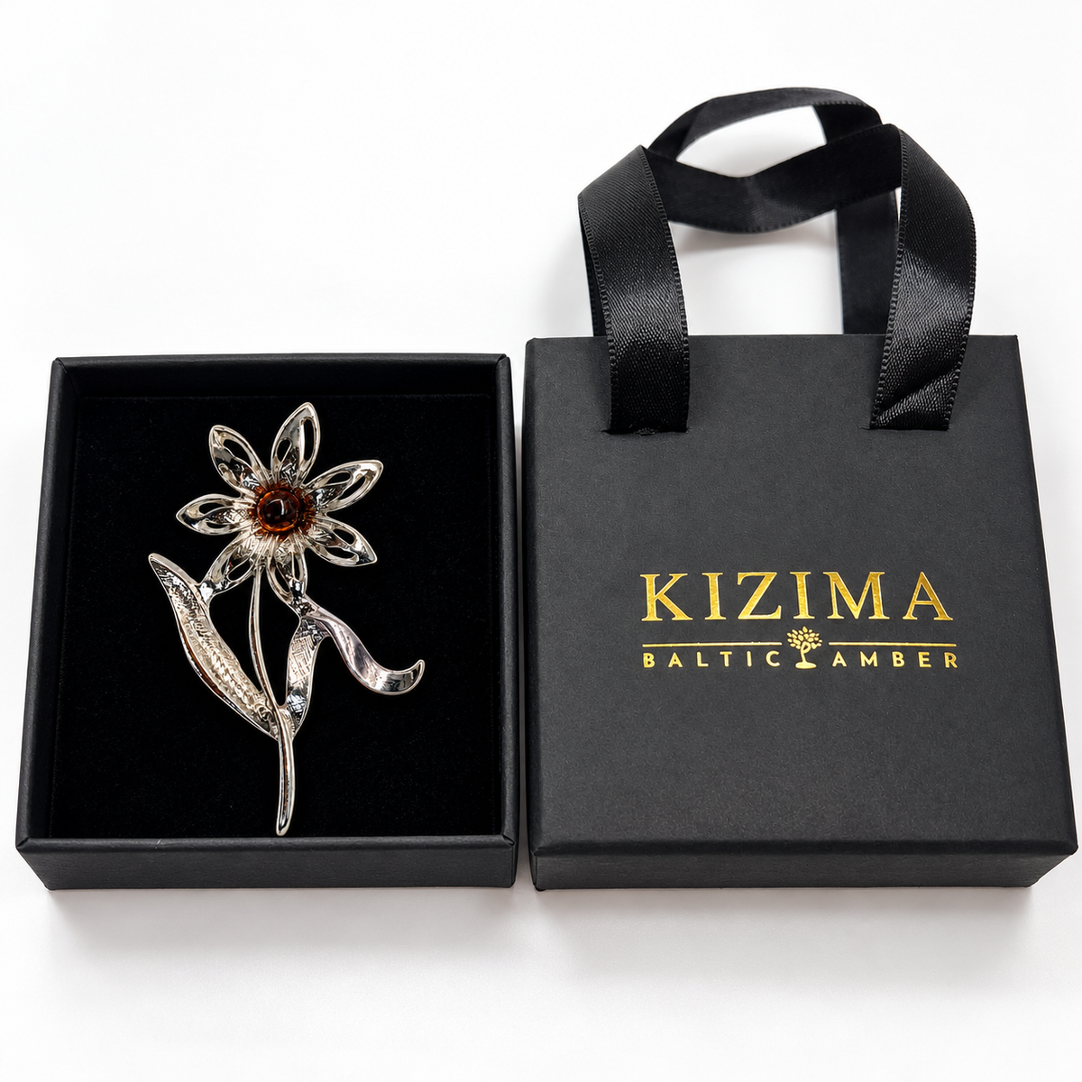 KIZIMA silver-tone seven-petal daisy with dark cognac amber center brooch in actual black KIZIMA gift packaging.