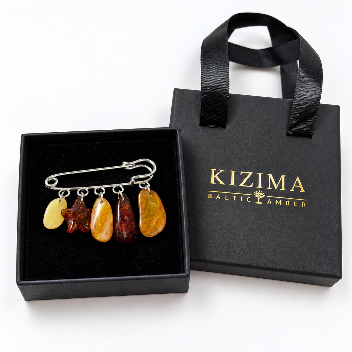 KIZIMA silver-tone safety pin brooch with five distinct yellow, golden and cognac Baltic amber charms in actual black KIZIMA gift packaging.
