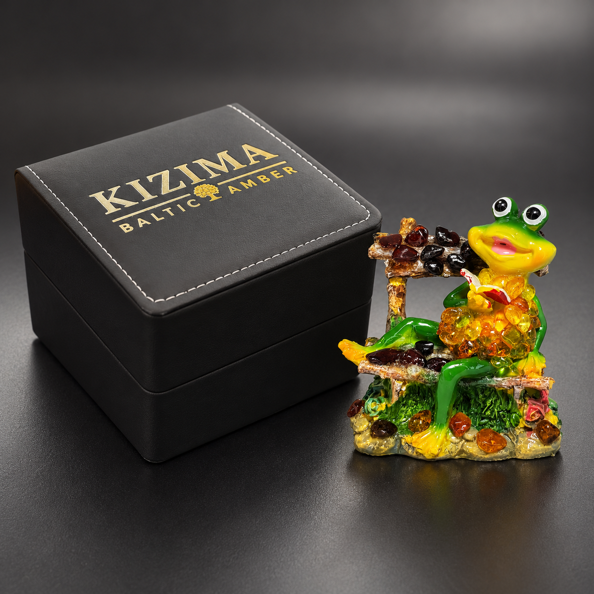 KIZIMA lucky frog figurine 662987478649 beside the genuine black stitched KIZIMA Baltic Amber gift box, shown at proportional scale.