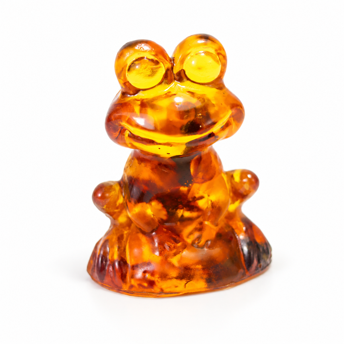 KIZIMA tiny seated amber frog figurine 9K0001q38 with round amber eyes and molded smile on a clean white background.