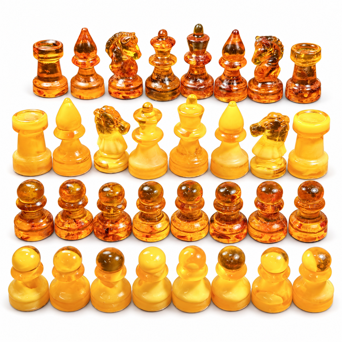 Complete 32-piece KIZIMA Baltic amber chess set in golden yellow and cognac, isolated on white with soft contact shadows.