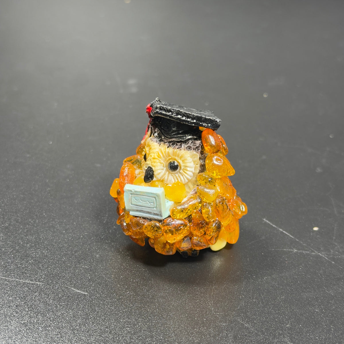 Original photograph of the OWL14 graduation owl figurine on a gray tabletop
