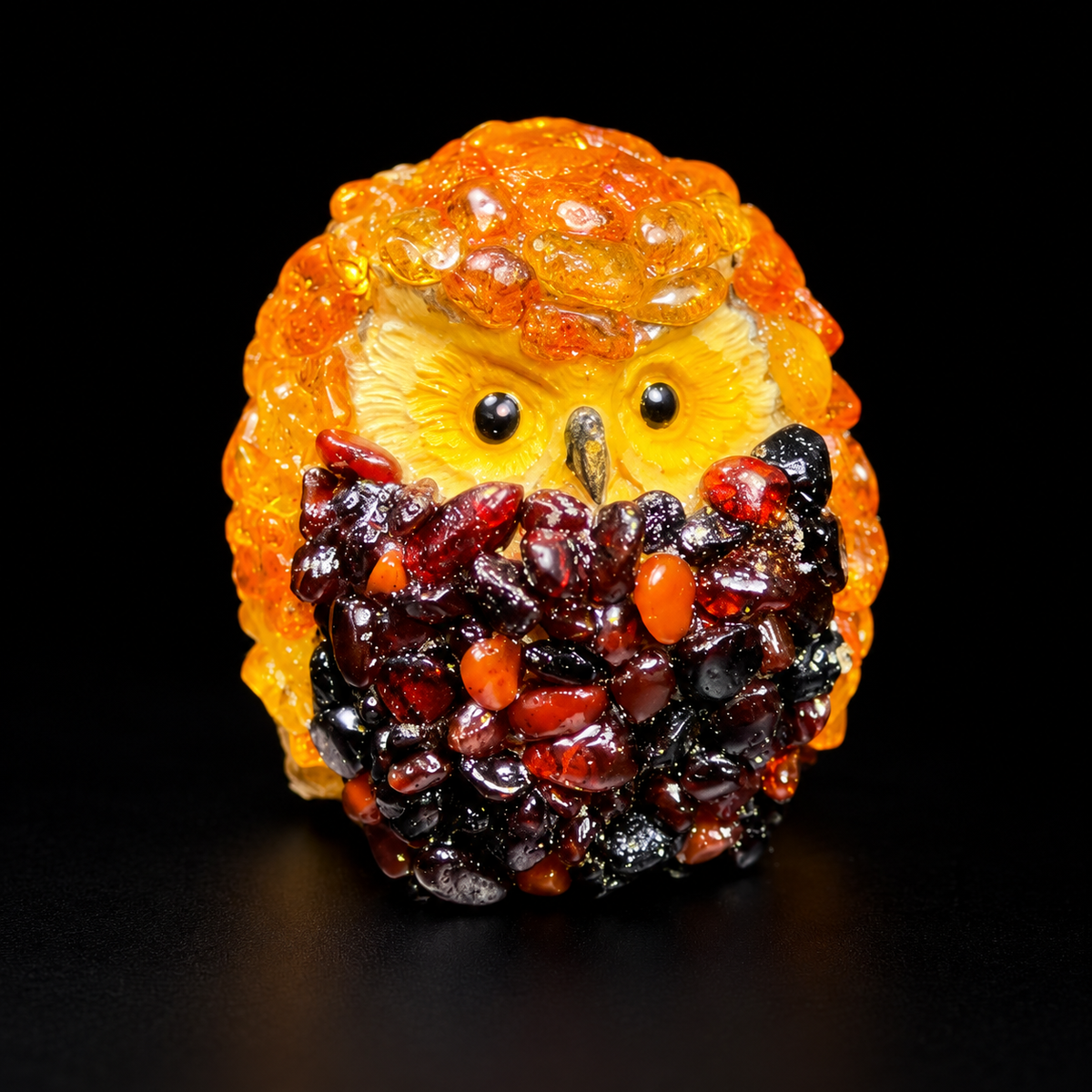 Front studio view of the compact golden-orange owl figurine against a black background