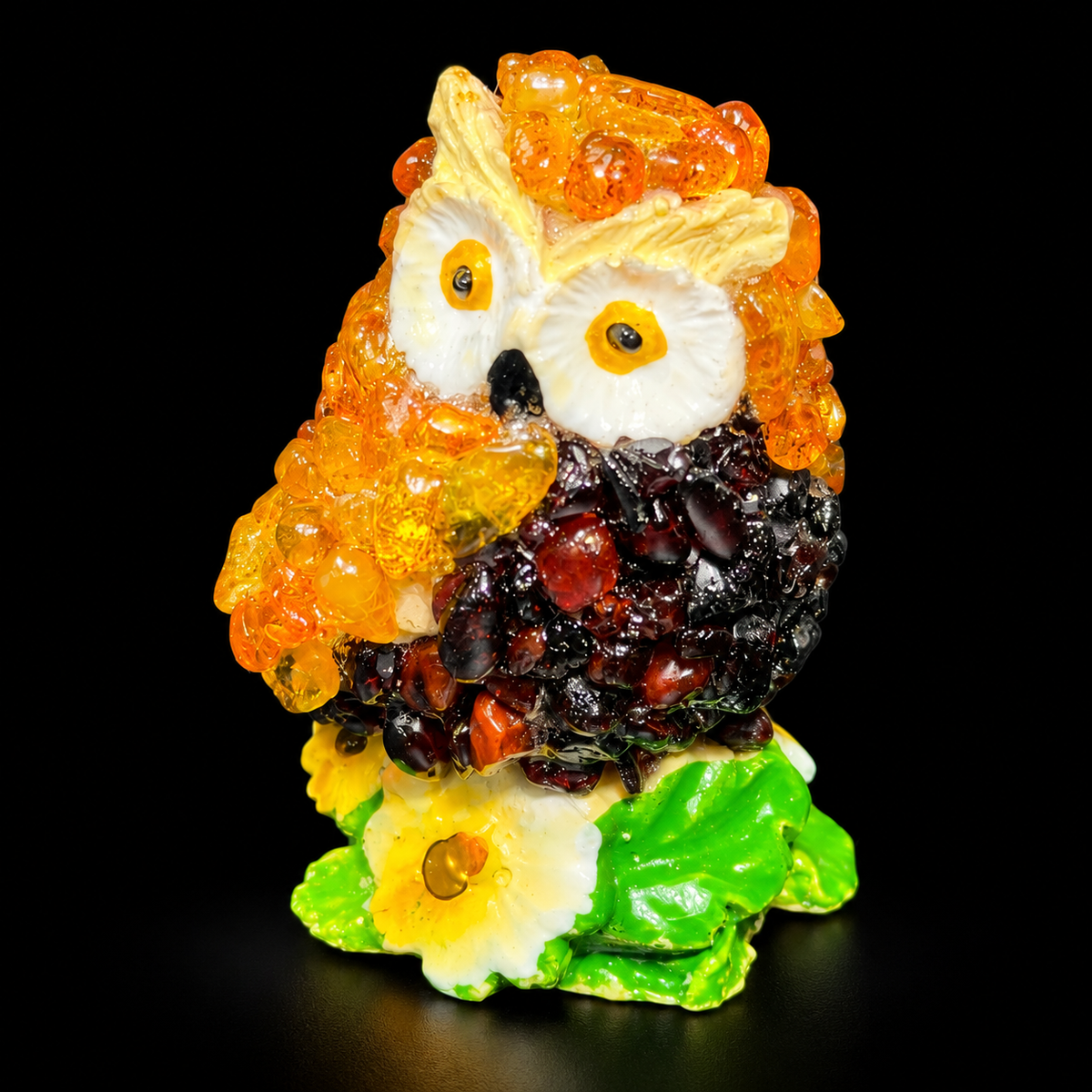 KIZIMA owl figurine with white eyes and green floral base on black studio background