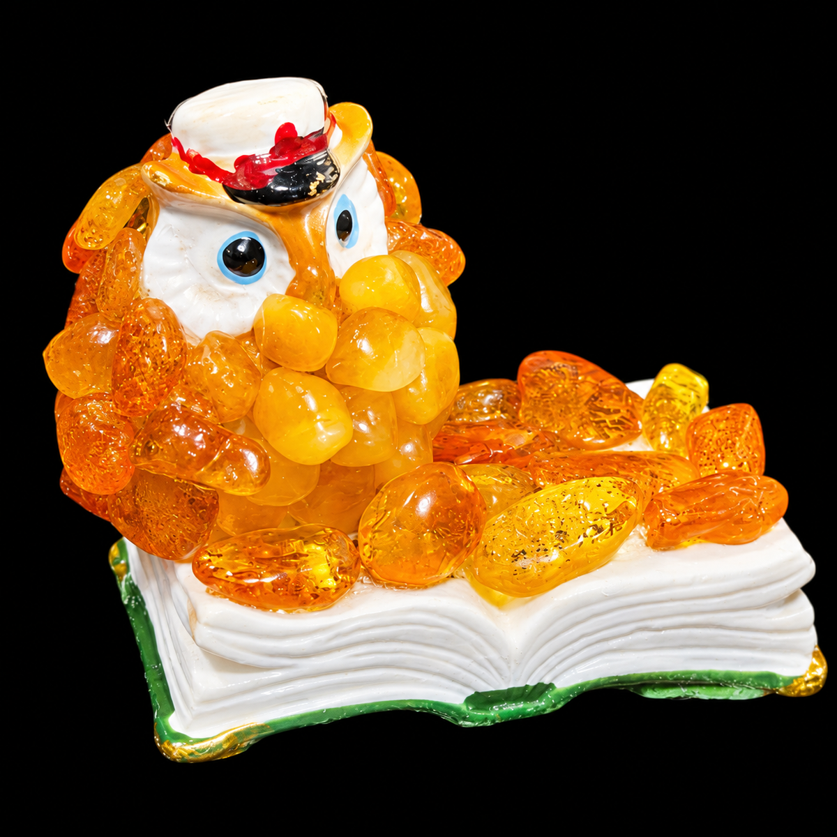 Close-up of orange owl with blue eyes and a white hat on a black studio background