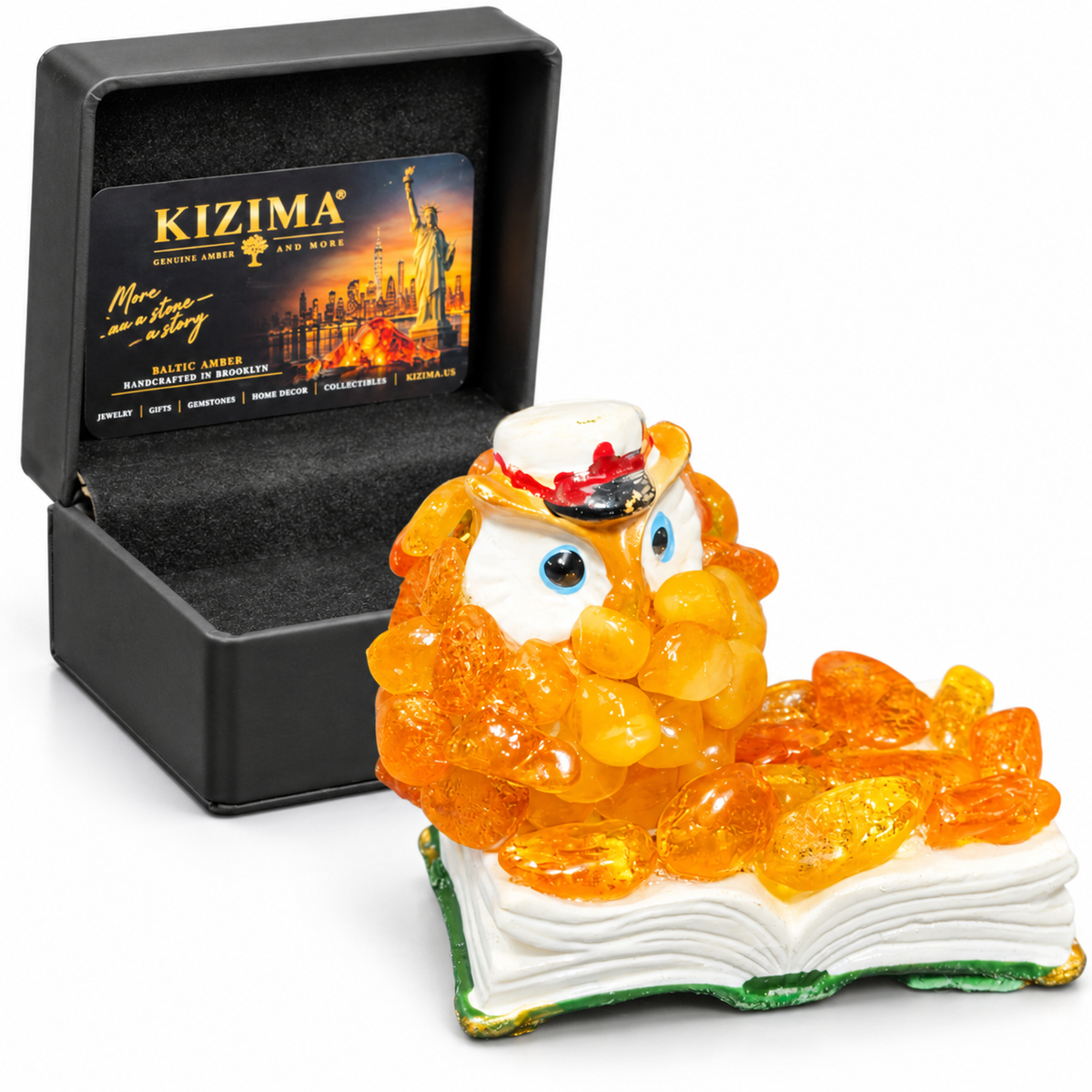 Single owl-on-book figurine beside its open black KIZIMA presentation box on white