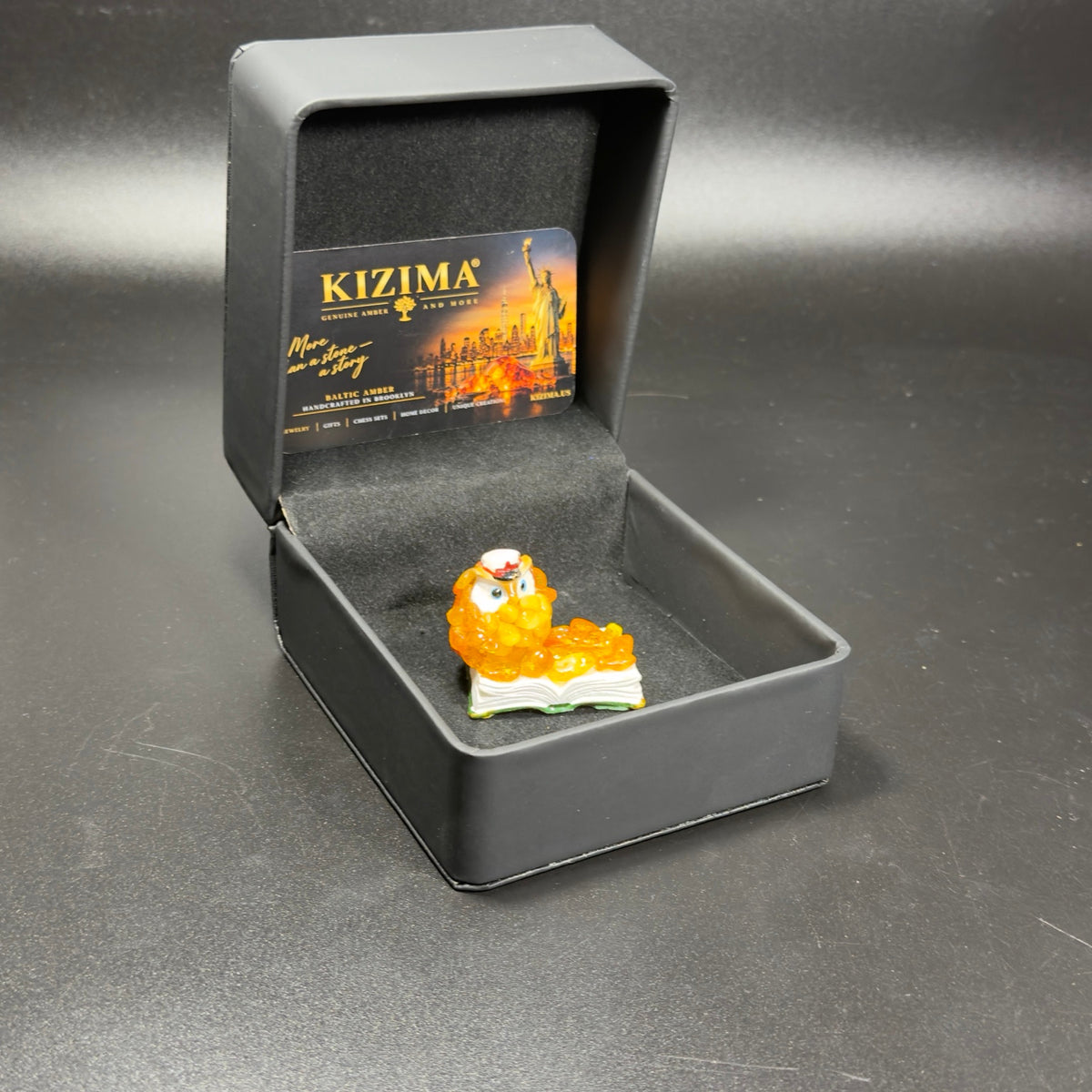 Original photograph of the amber owl figurine in the open KIZIMA box.