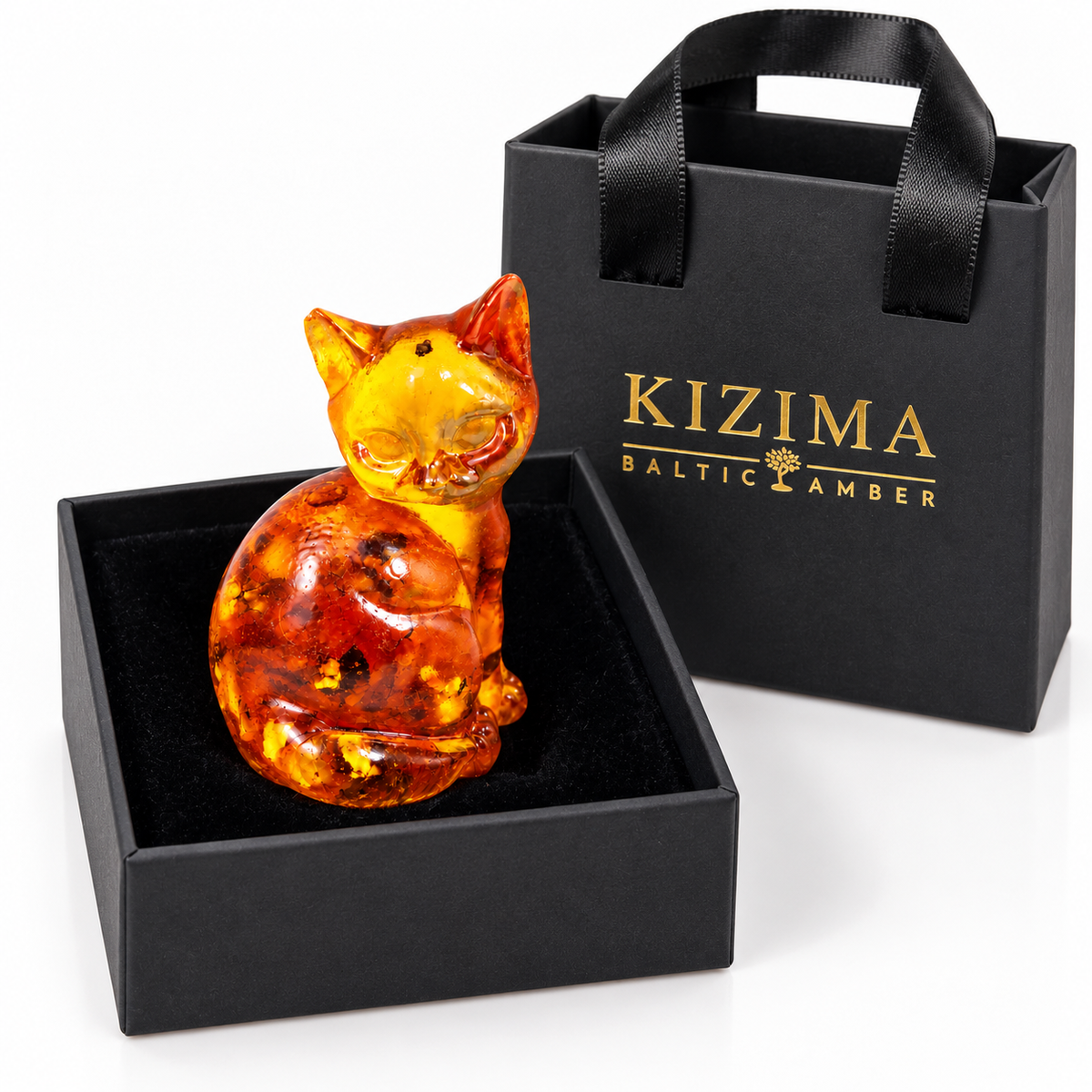 Rounded amber sitting cat inside a black velvet-lined KIZIMA gift box with branded bag