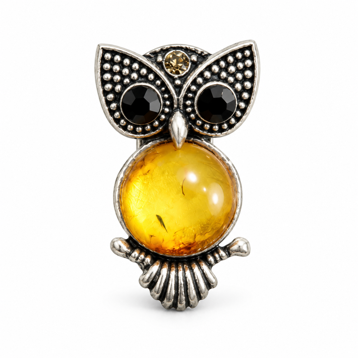 KIZIMA small silver-tone owl brooch with black eyes and honey-yellow Baltic amber belly on white studio background.
