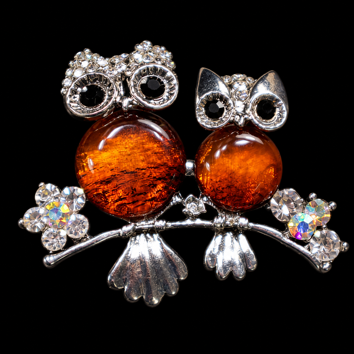 KIZIMA two cognac amber owls on branch brooch 20-202Q13-5-4-1, black studio background.