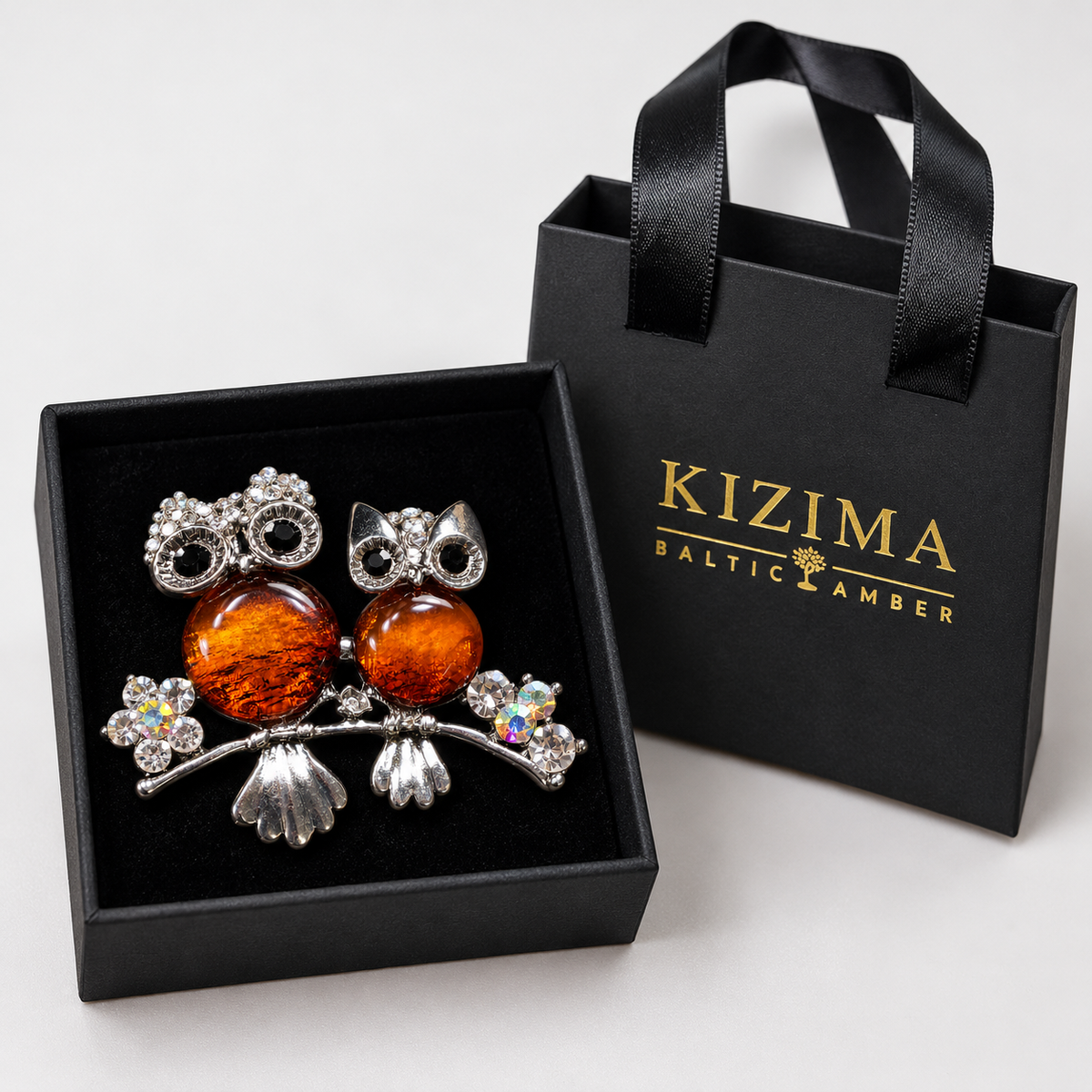 KIZIMA two cognac amber owls on branch brooch 20-202Q13-5-4-1, with actual KIZIMA gift packaging.