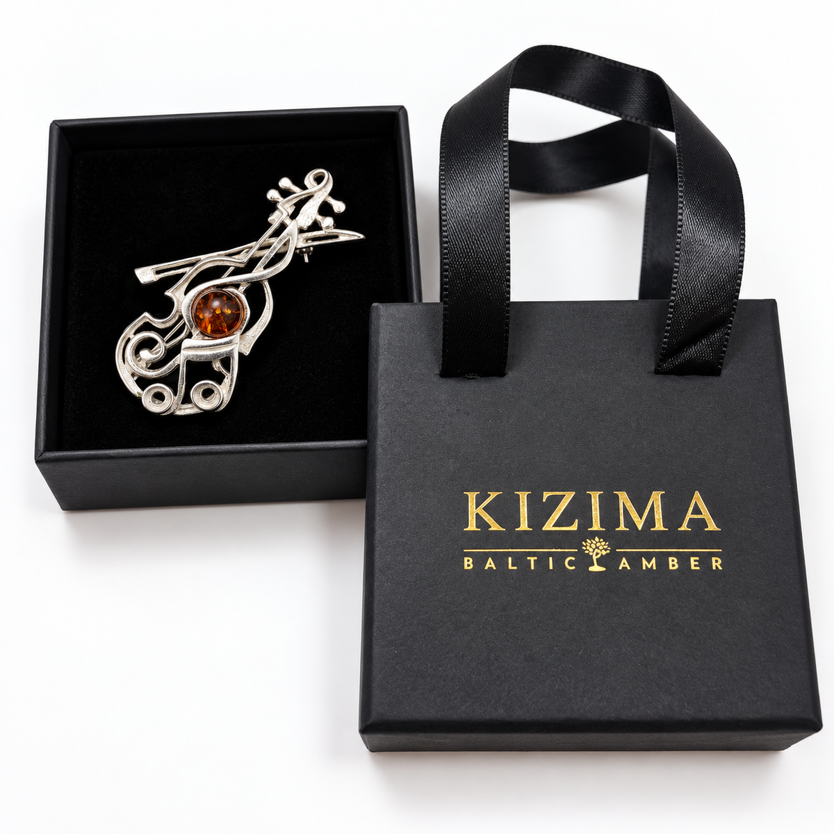 KIZIMA silver-tone violin and bow brooch with cognac Baltic amber on actual KIZIMA black gift packaging.