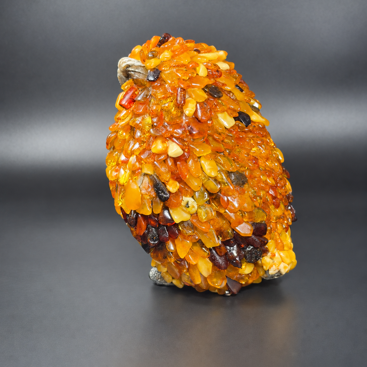 Enhanced original left-facing profile of KIZIMA VIP amber owl 5598752O, showing layered amber stones on its wing and side.