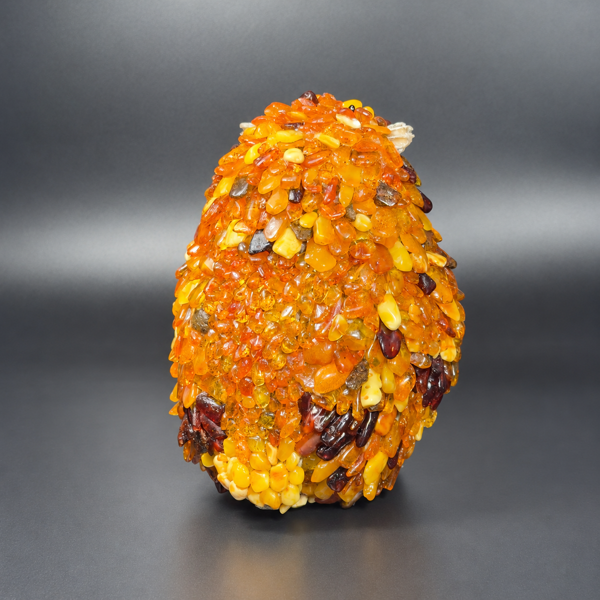 Enhanced original rear view of KIZIMA VIP amber owl 5598752O, showing honey-colored amber mosaic and dark wing markings.