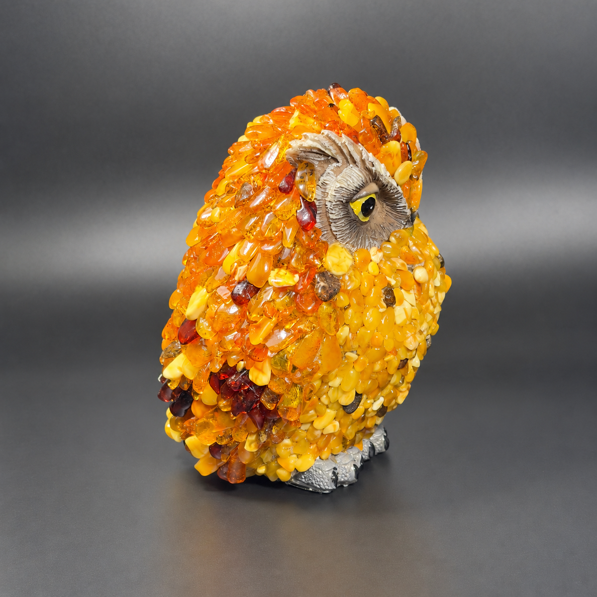 Enhanced original right-facing profile of KIZIMA VIP amber owl 5598752O, showing its gray face, yellow eye and raised amber texture.