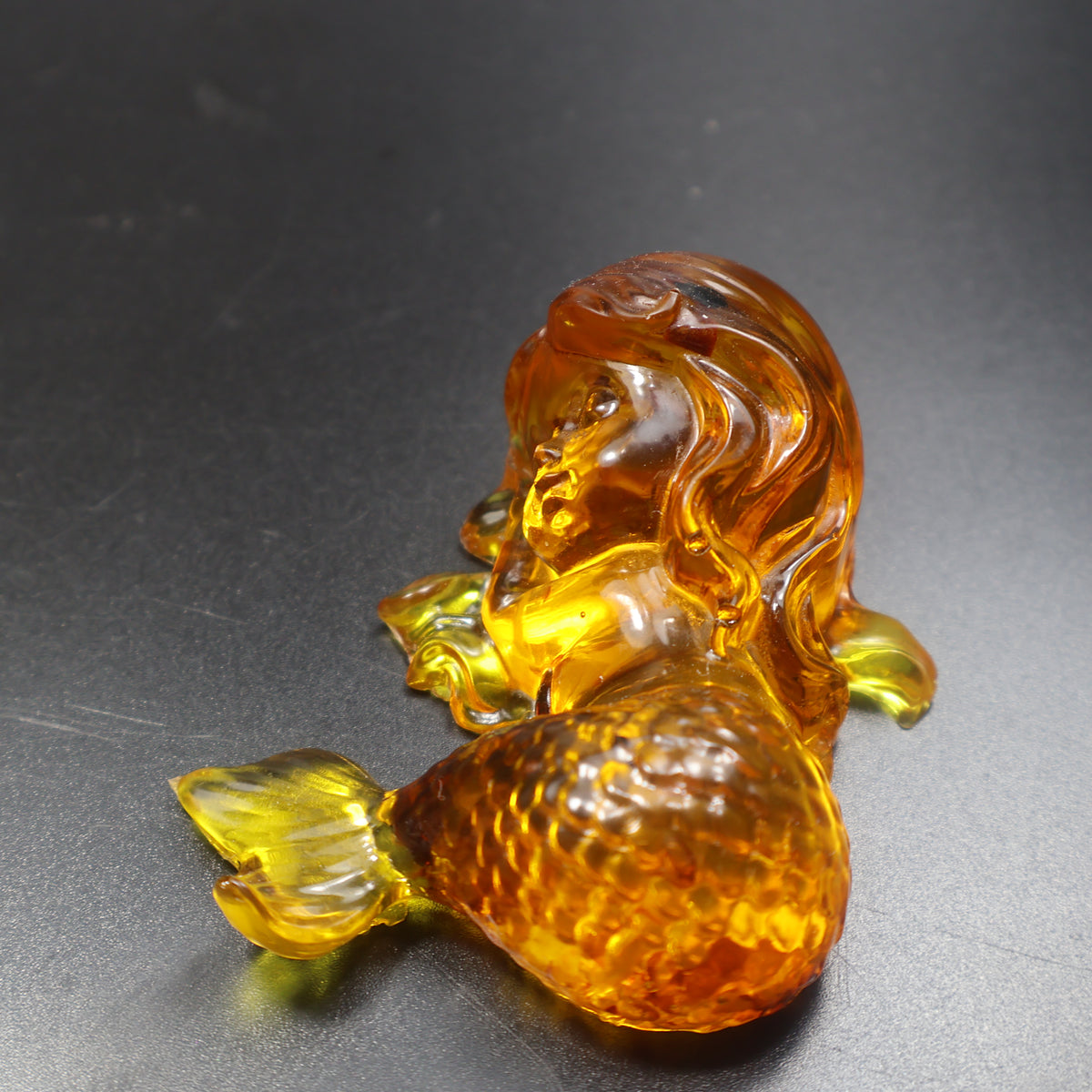 Baltic amber small lying mermaid figurine by KIZIMA® — three-quarter view in cognac and honey amber