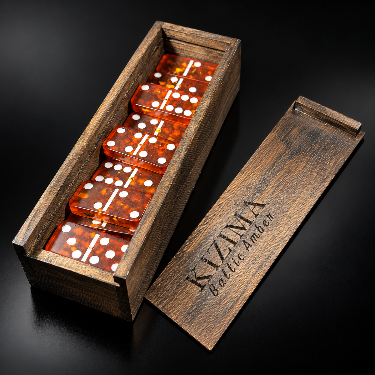 Cherry Natural Baltic Amber domino set in an engraved KIZIMA® wooden box on black studio background — handmade double-6 dominoes, Made in USA