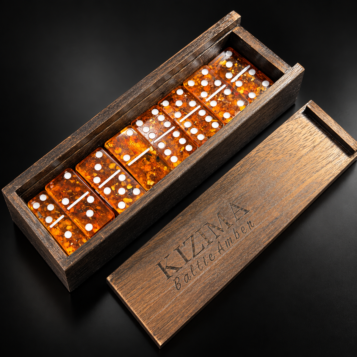 Classic cognac Baltic amber domino set in an engraved KIZIMA® wooden box on black studio background — handmade double-6 dominoes, Made in USA