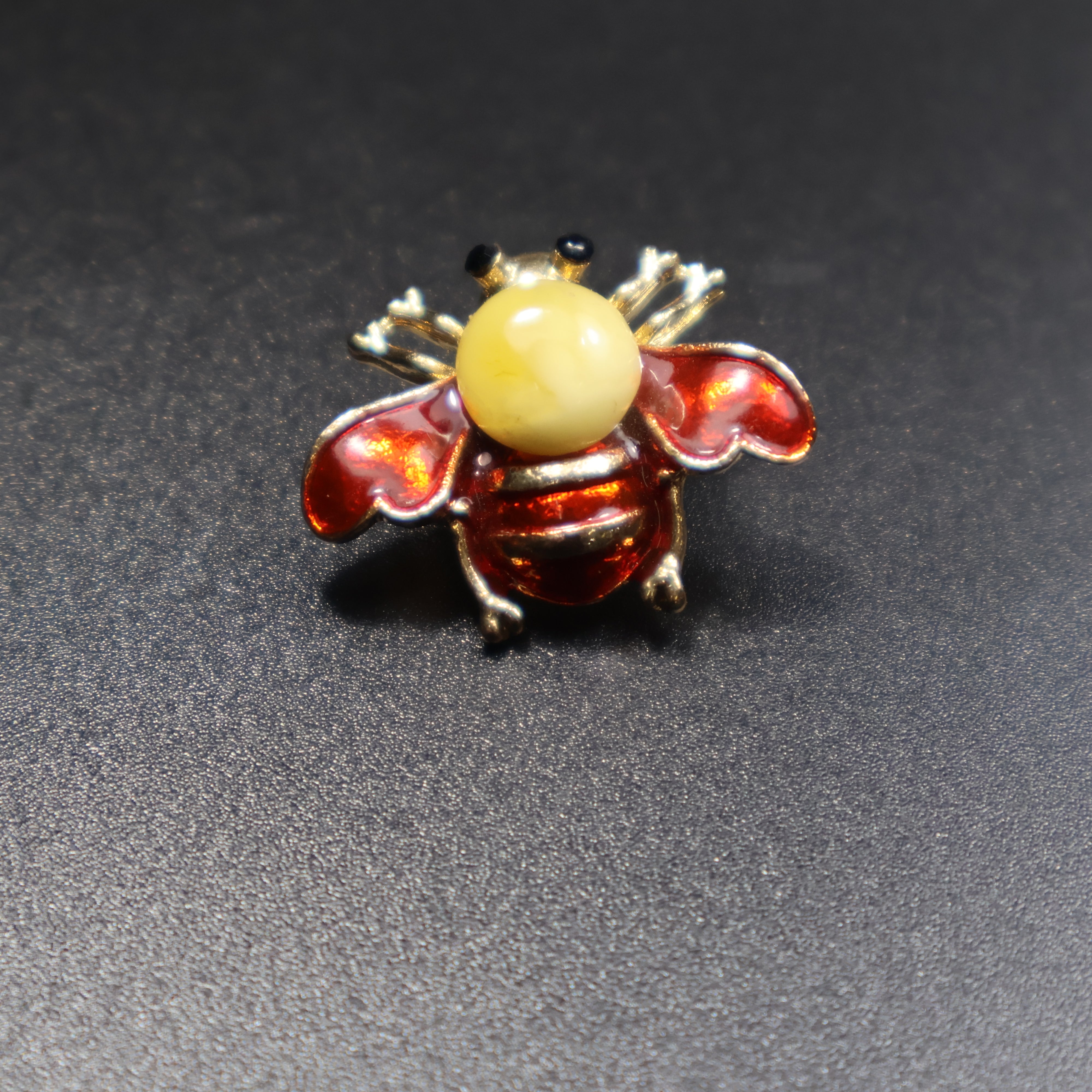 Handmade Baltic amber bee brooch red variant close-up