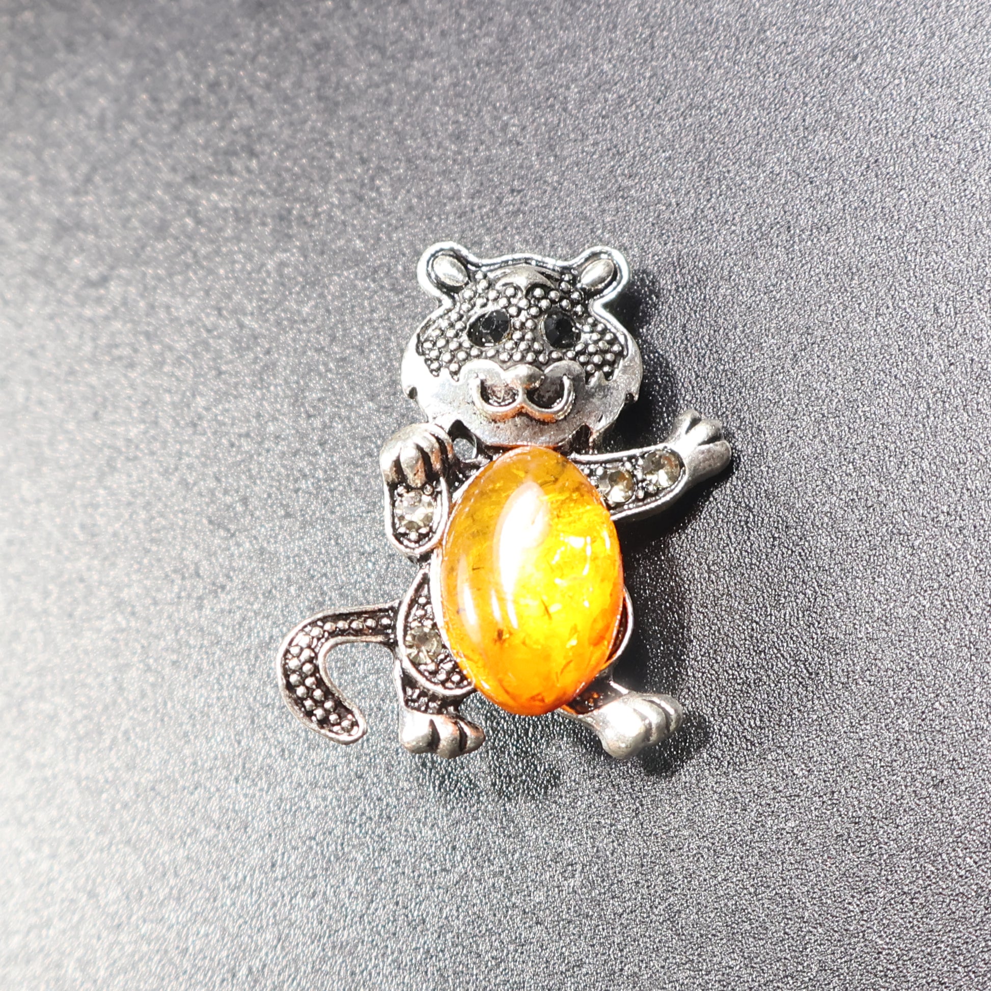 Handmade Baltic amber cat brooch silver amber tail down close-up honey stone
