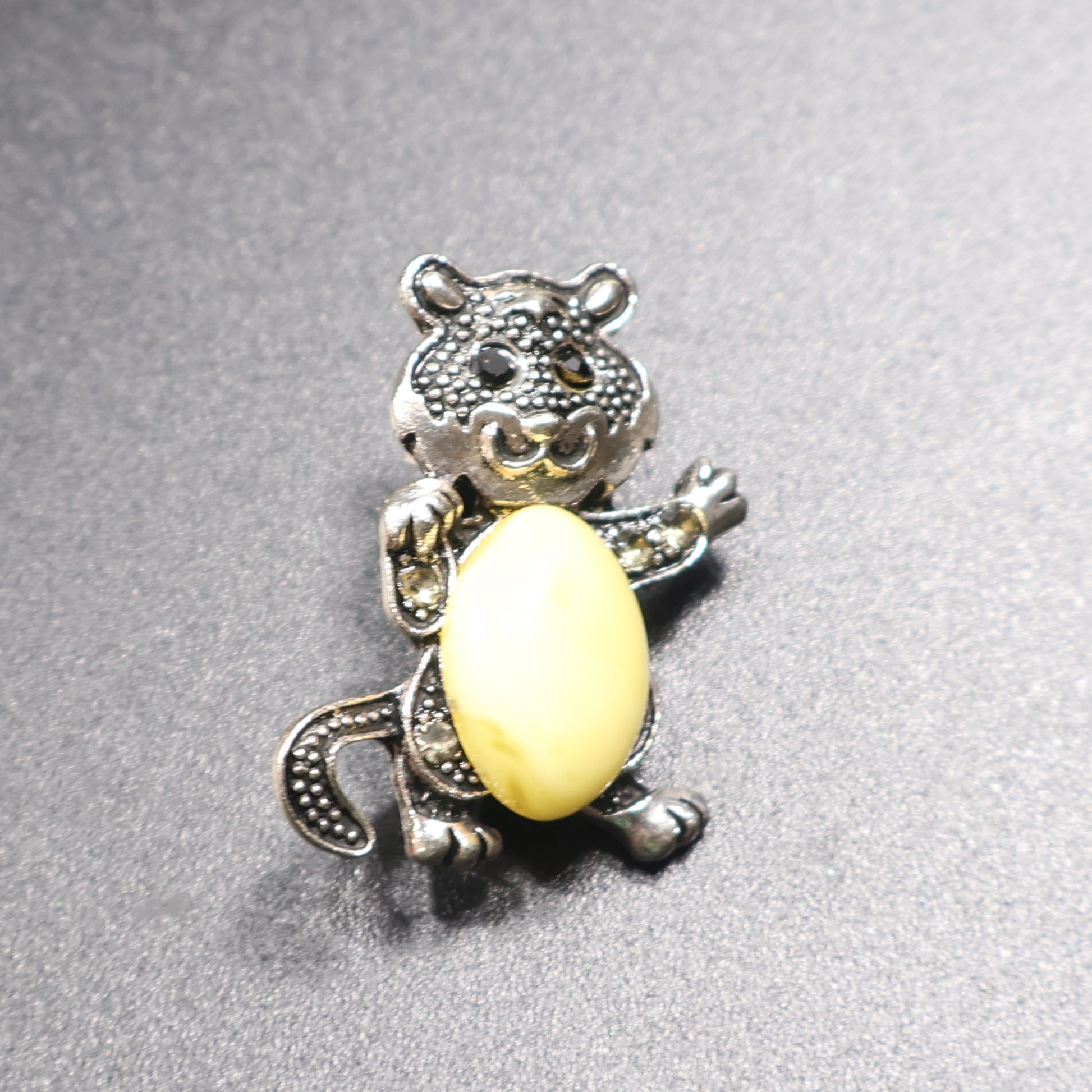 Genuine Baltic amber cat brooch silver tail down front view cream stone