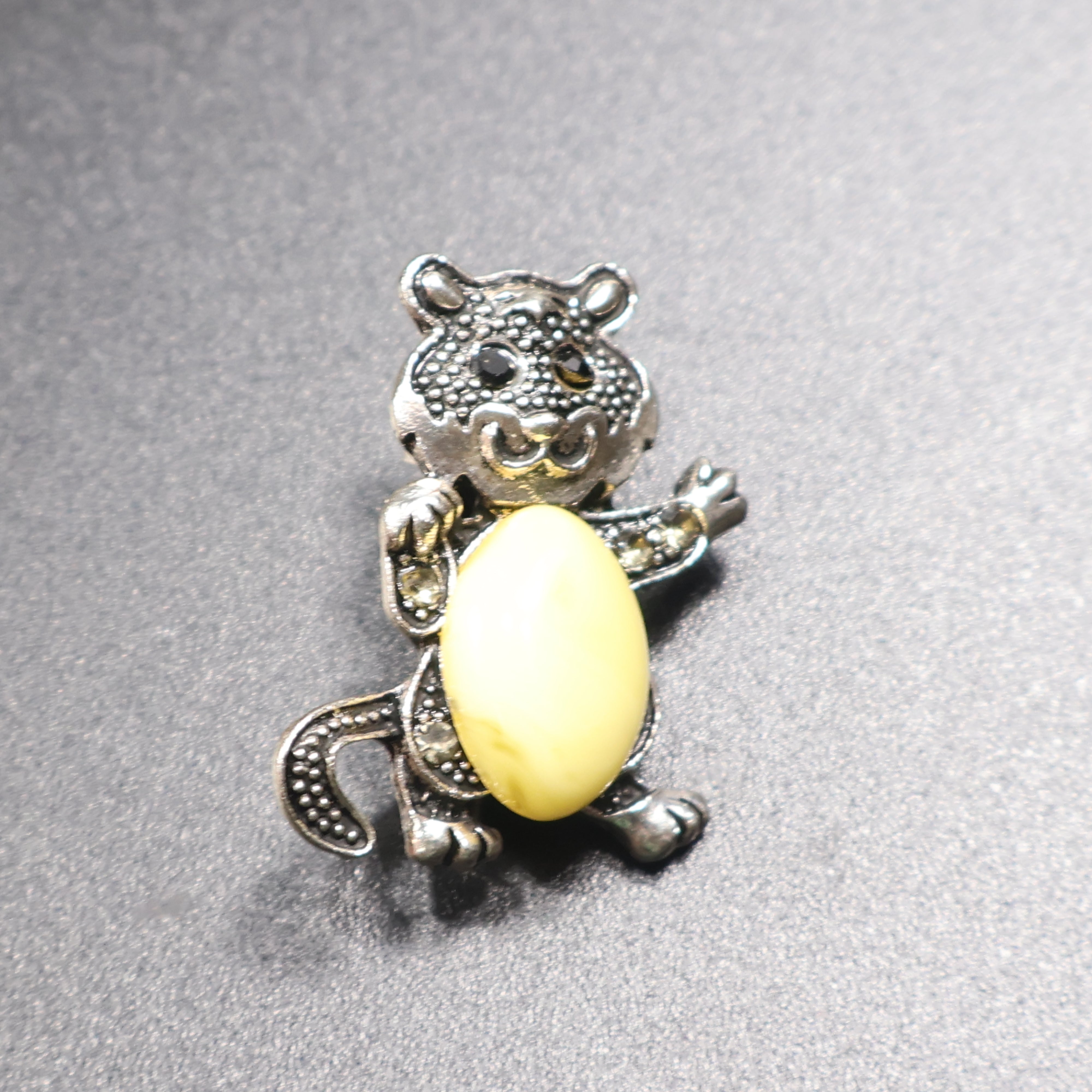Genuine Baltic amber cat brooch silver tail down front view cream stone