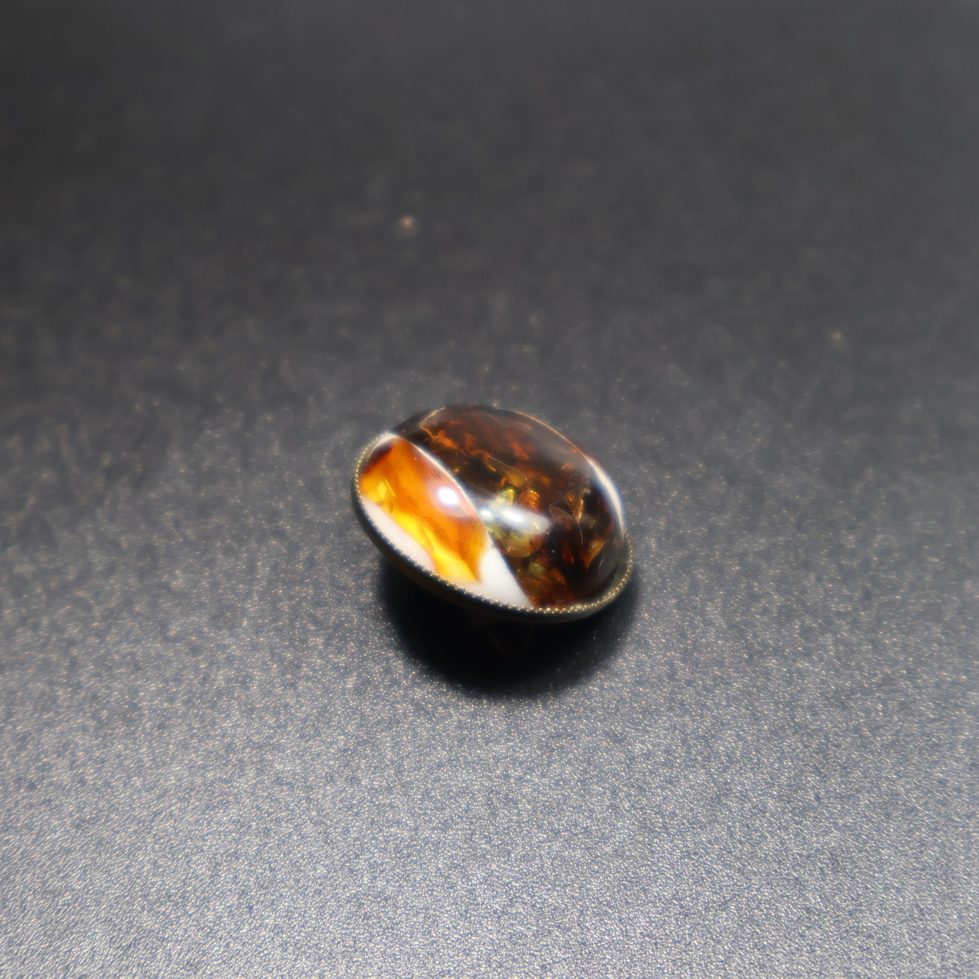Handmade Baltic amber dalmatian brooch close-up showing natural stone