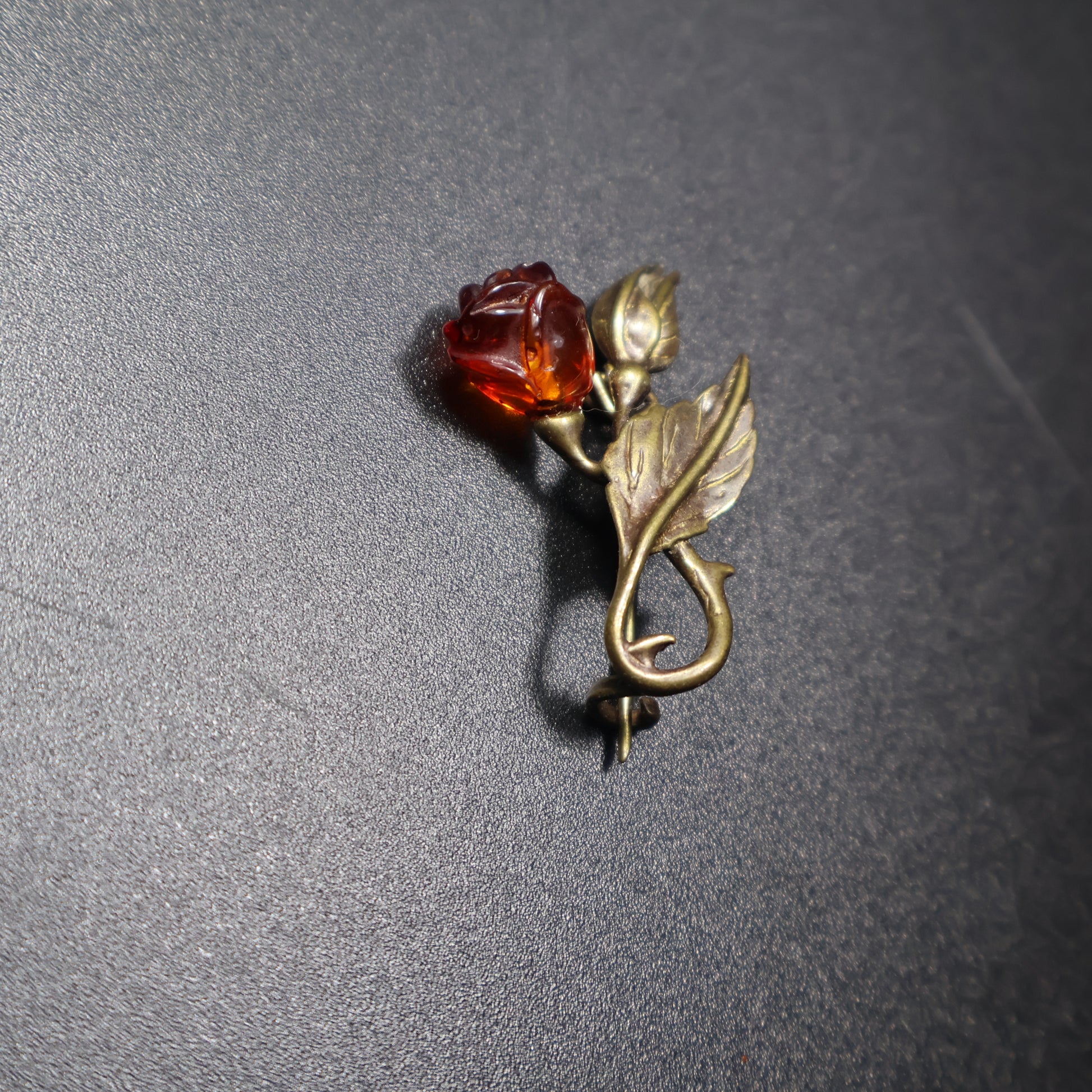 Handmade Baltic amber flower bud brooch close-up showing natural stone