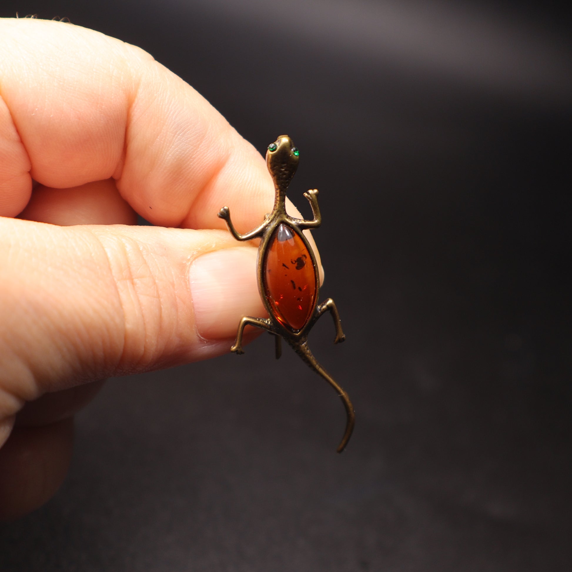 Handmade Baltic amber lizard brooch close-up showing natural stone