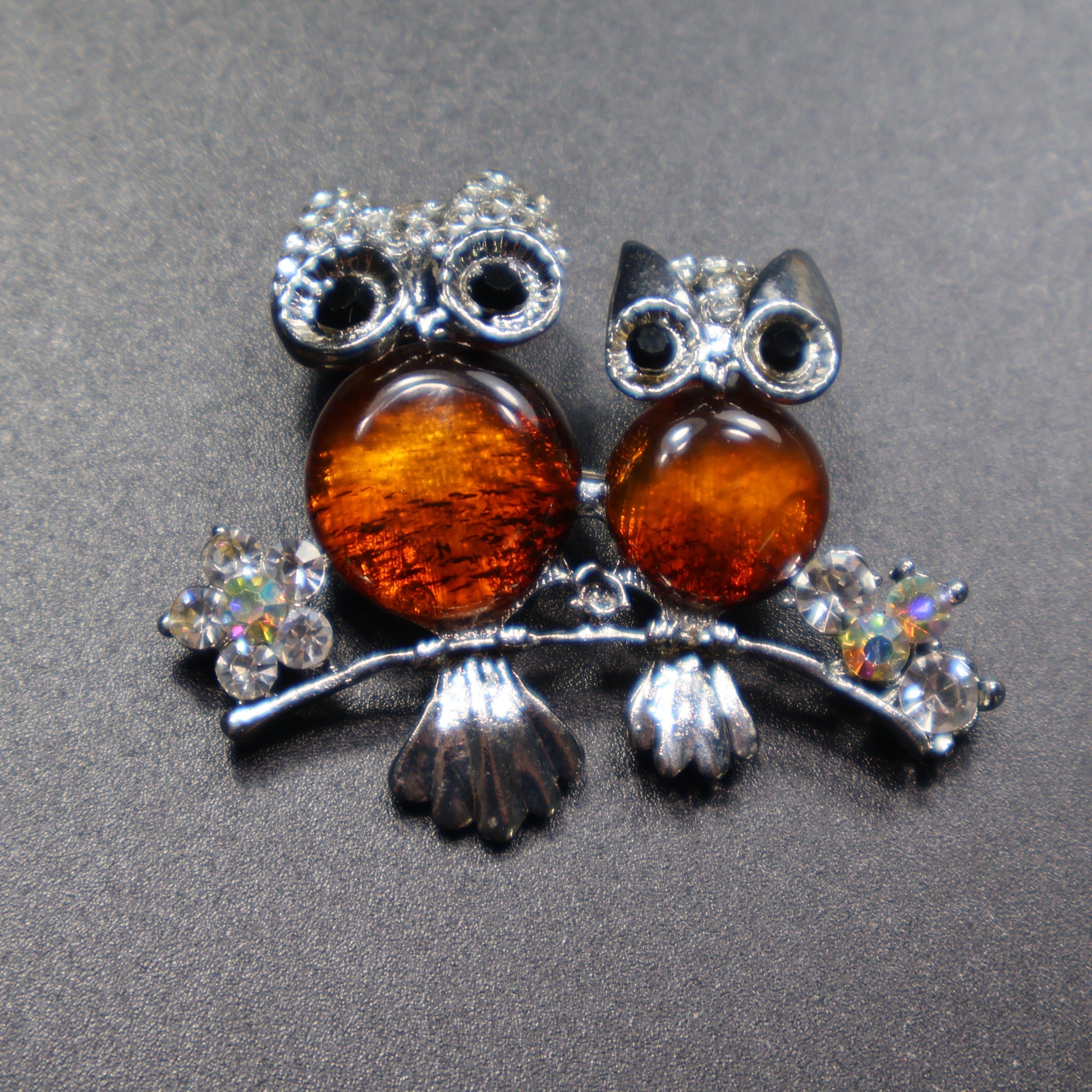 Handmade Baltic amber owl brooch close-up showing natural stone