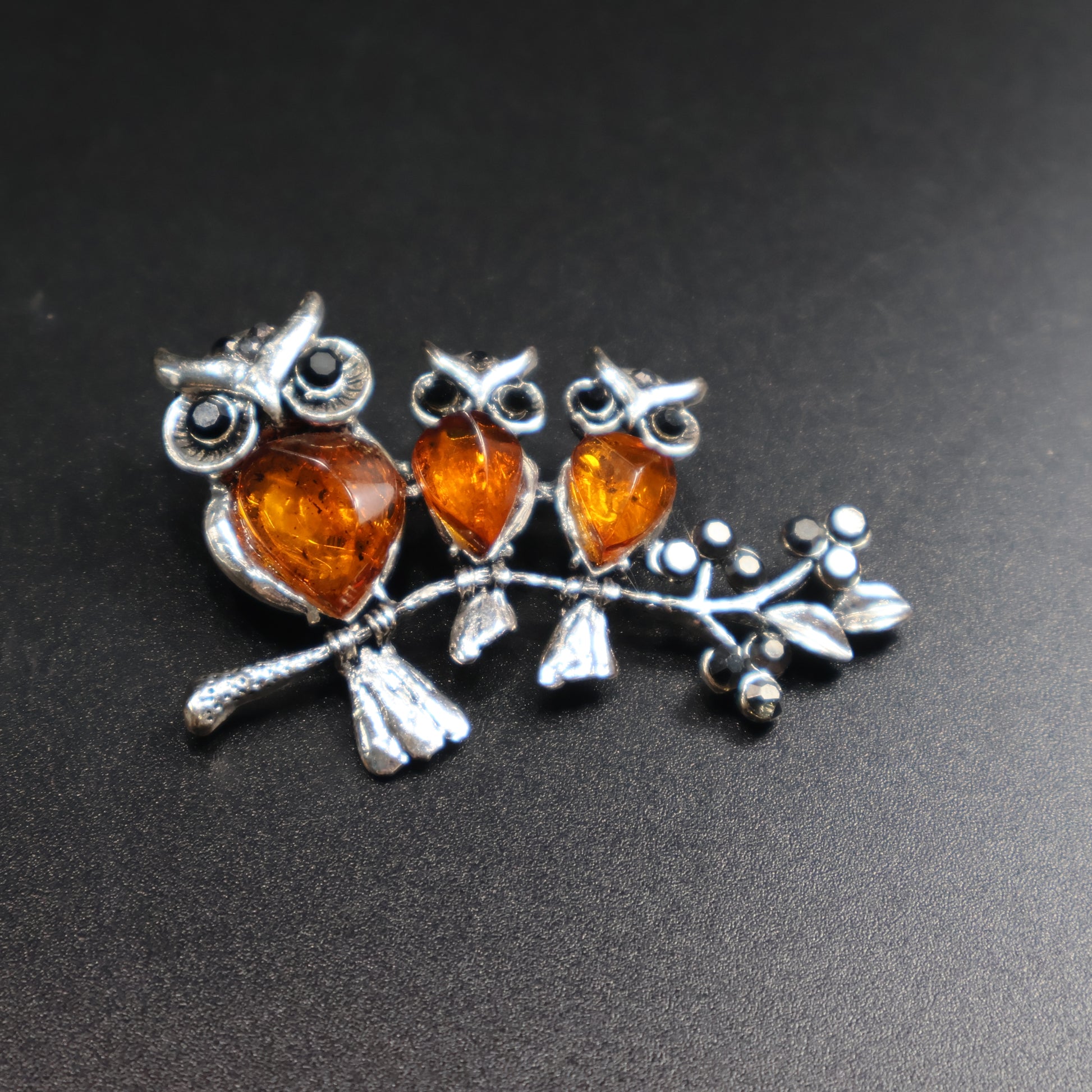 Natural Baltic amber three owls brooch worn as jewelry accessory
