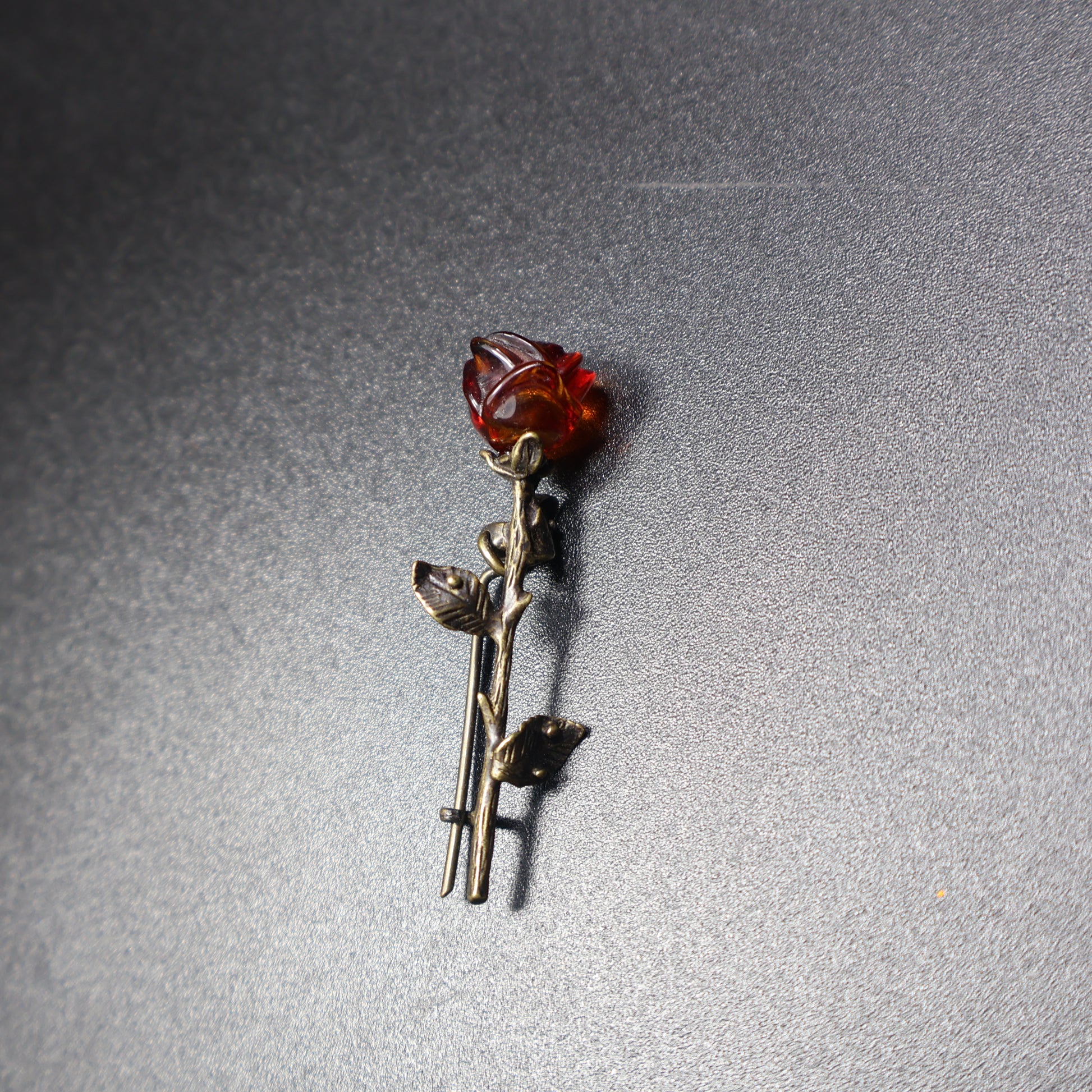 Handmade Baltic amber rose brooch close-up showing natural stone