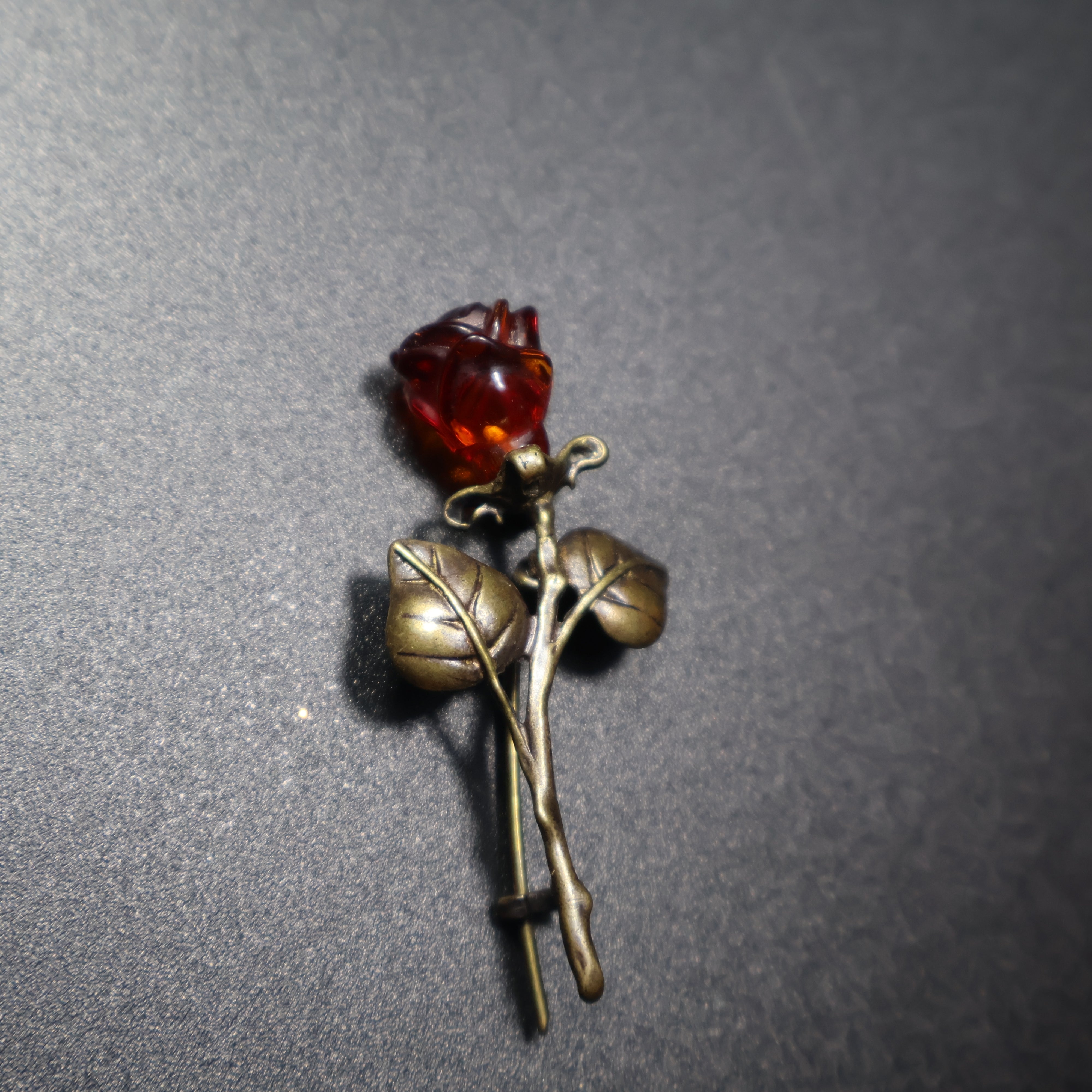 Handmade Baltic amber rose brooch close-up showing natural stone